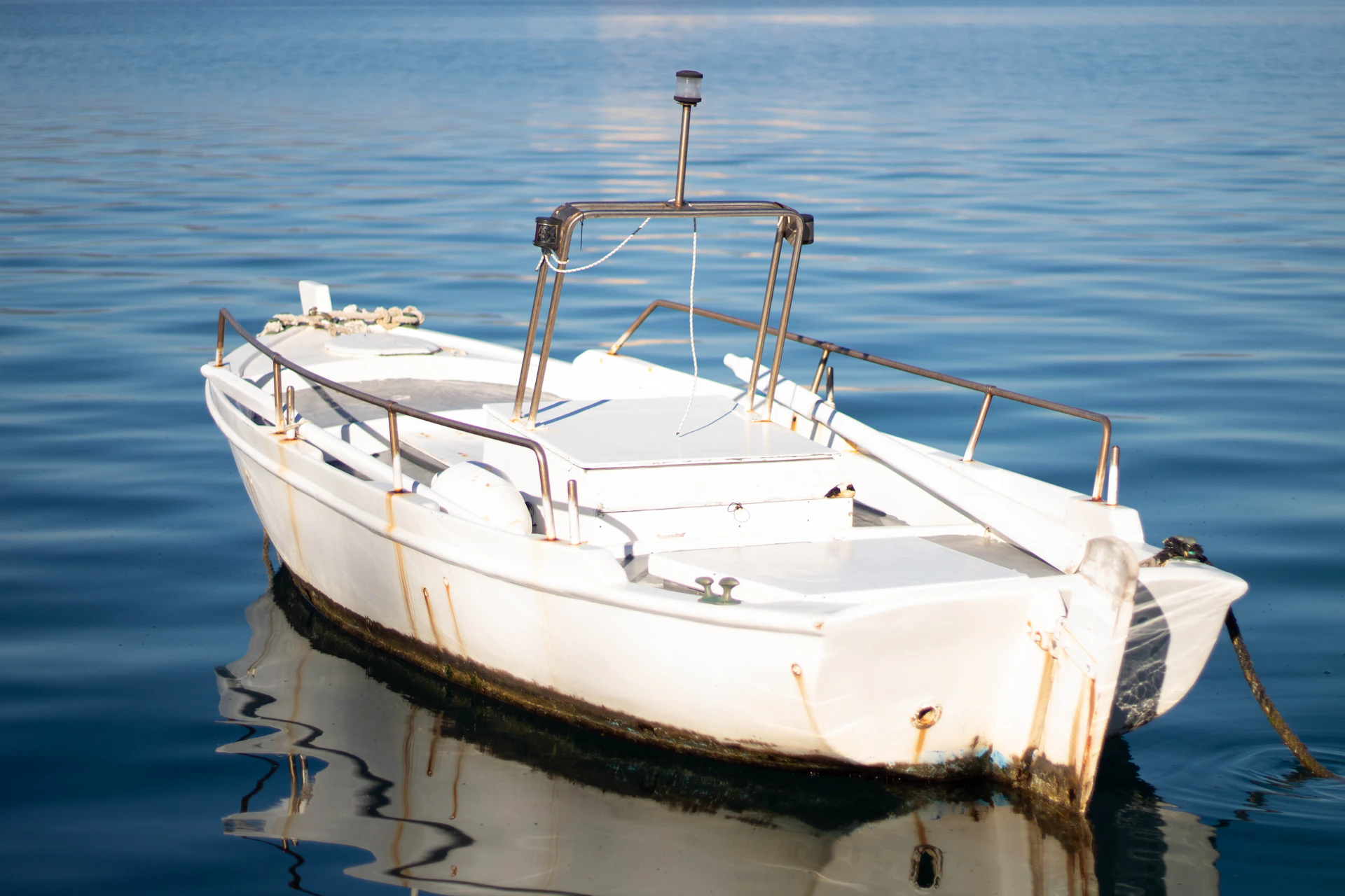 A white boat floats in blue water.