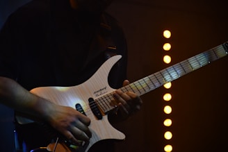 A musician plays an electric guitar on stage.