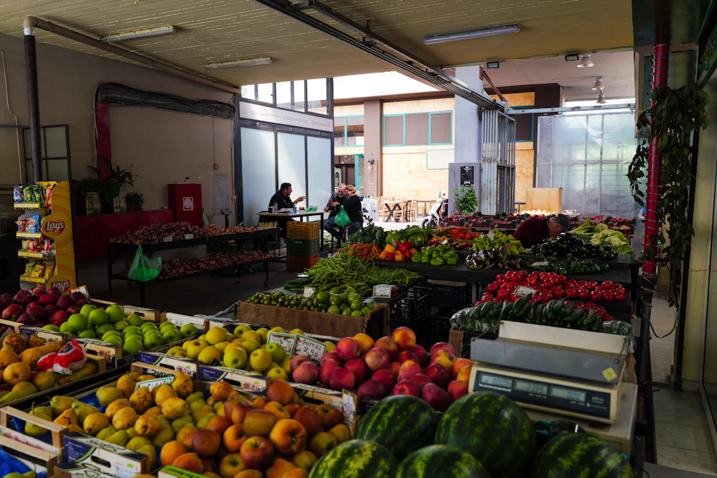 Produce is displayed at an indoor market.