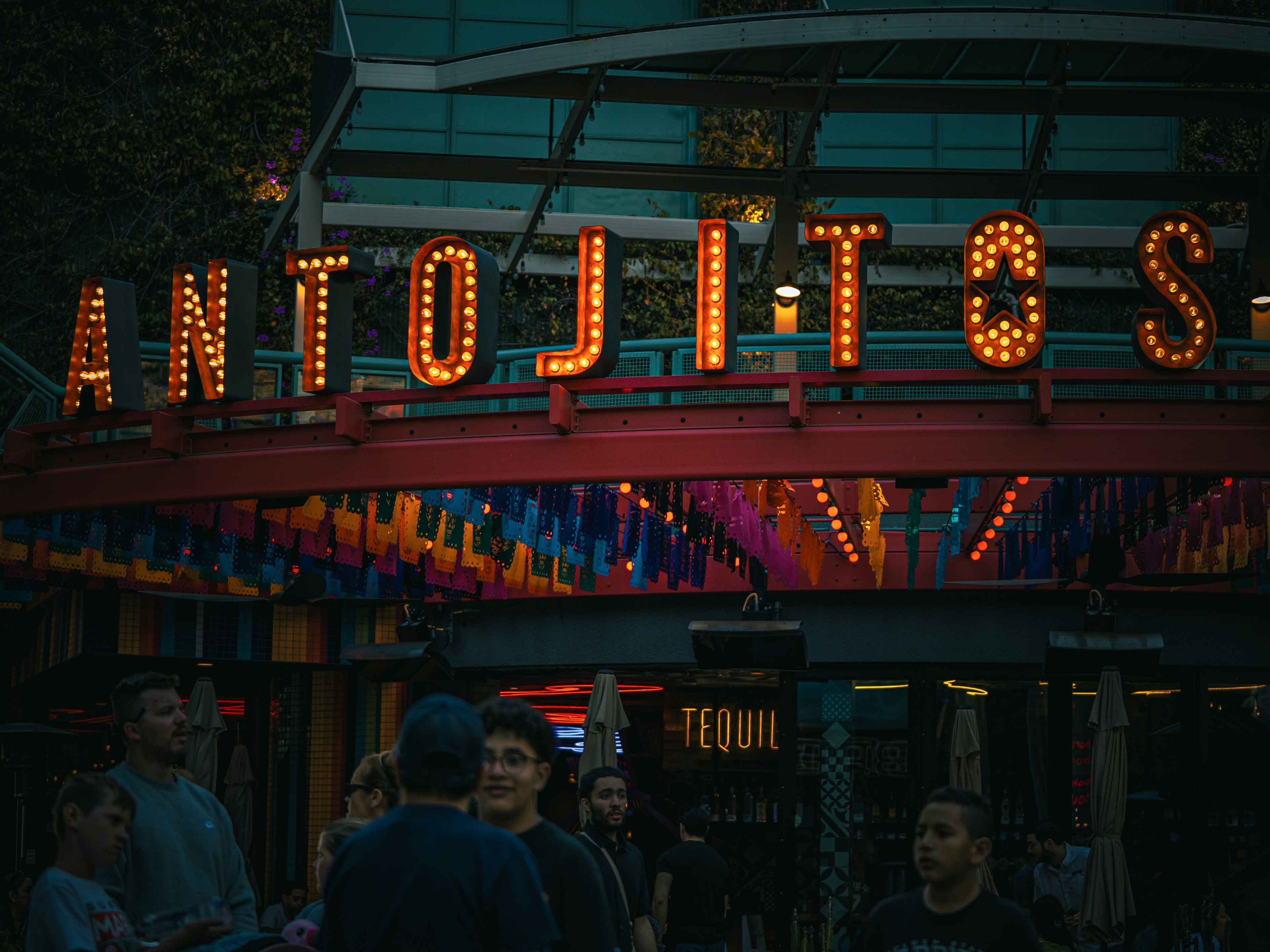 Antojitos restaurant sign glows in the night.