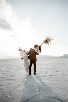 A newlywed couple celebrates with a kiss.