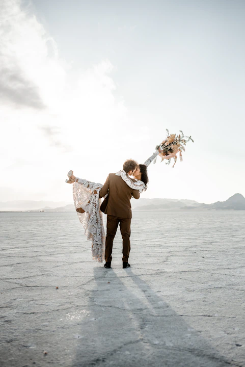 A newlywed couple celebrates with a kiss.