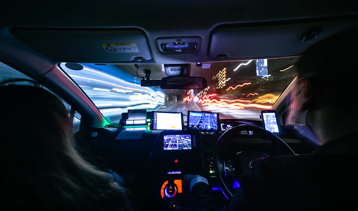 Blurry city street lights seen from inside a car at night.
