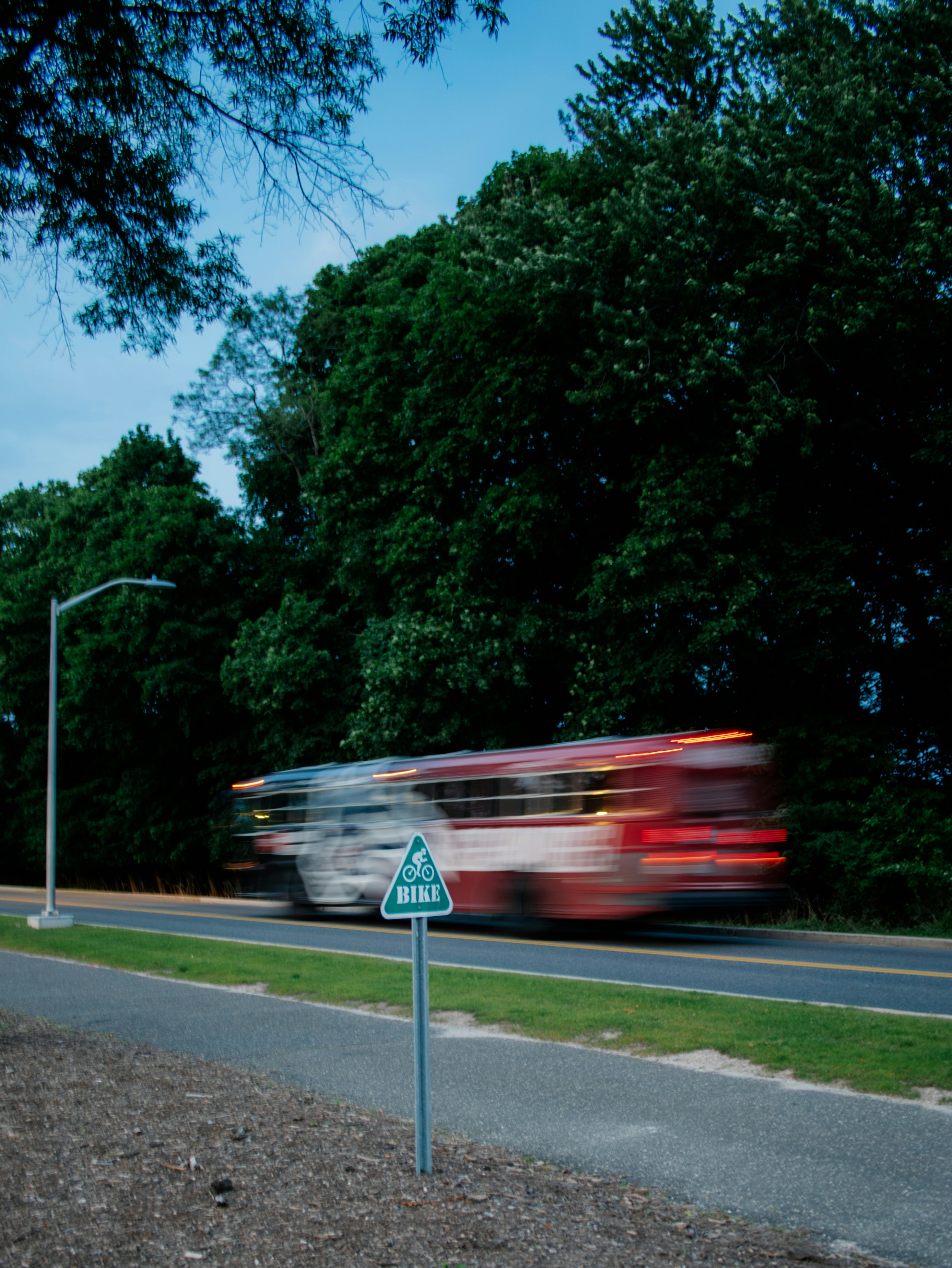 A blurry bus speeds along a road.
