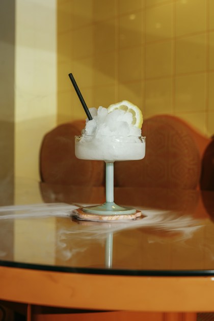 Granita au citron servie dans une coupe en verre avec tranche de citron