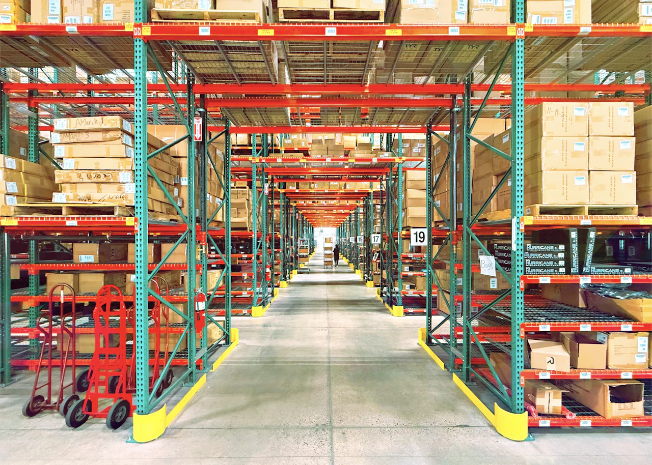 Rows of warehouse shelving and stock representing the inventory layers a dispensary platform tracks automatically