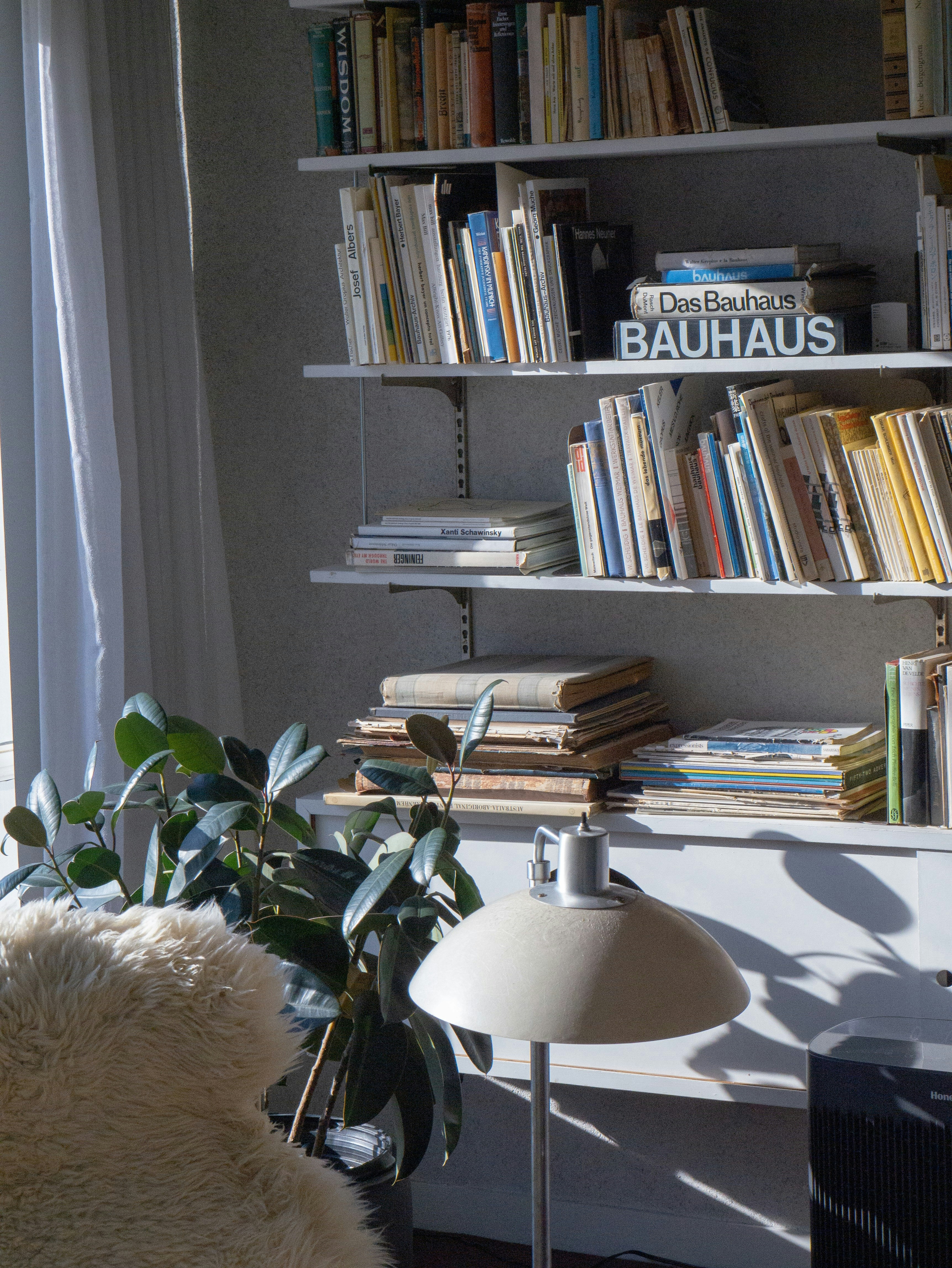 Books and a lamp sit near a bookshelf
