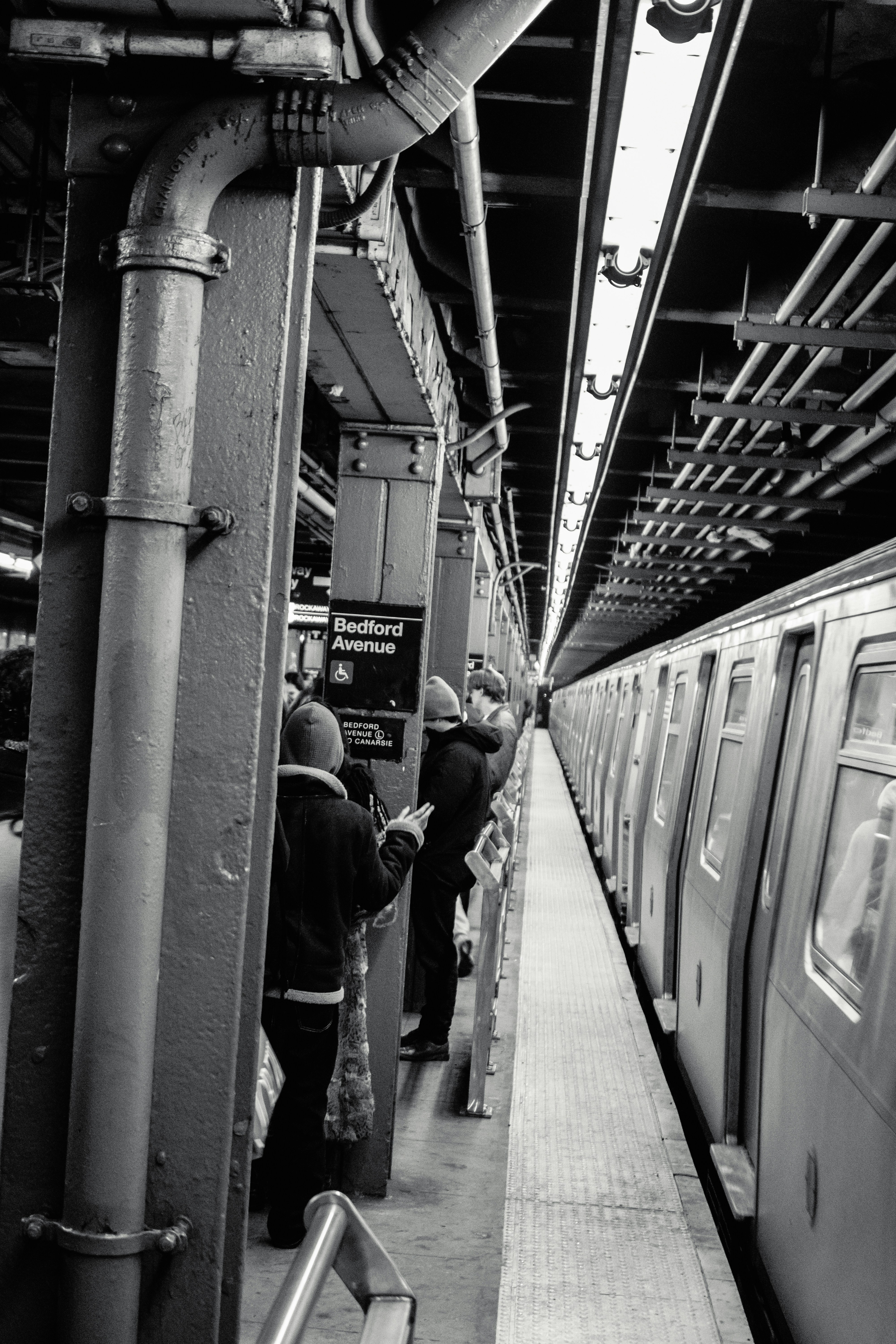 People wait for a subway train on a platform.