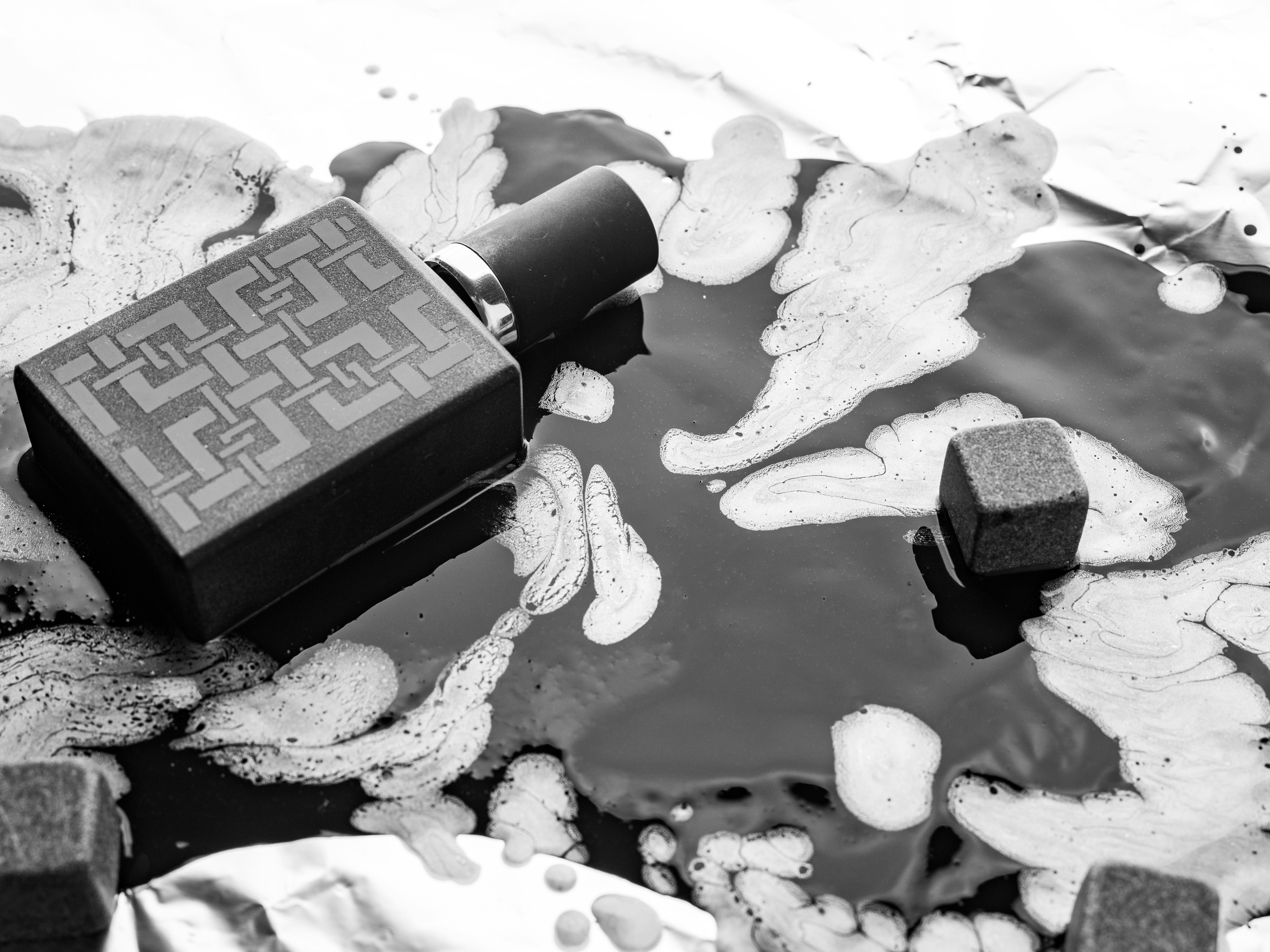 Perfume bottle on a dark, textured surface.