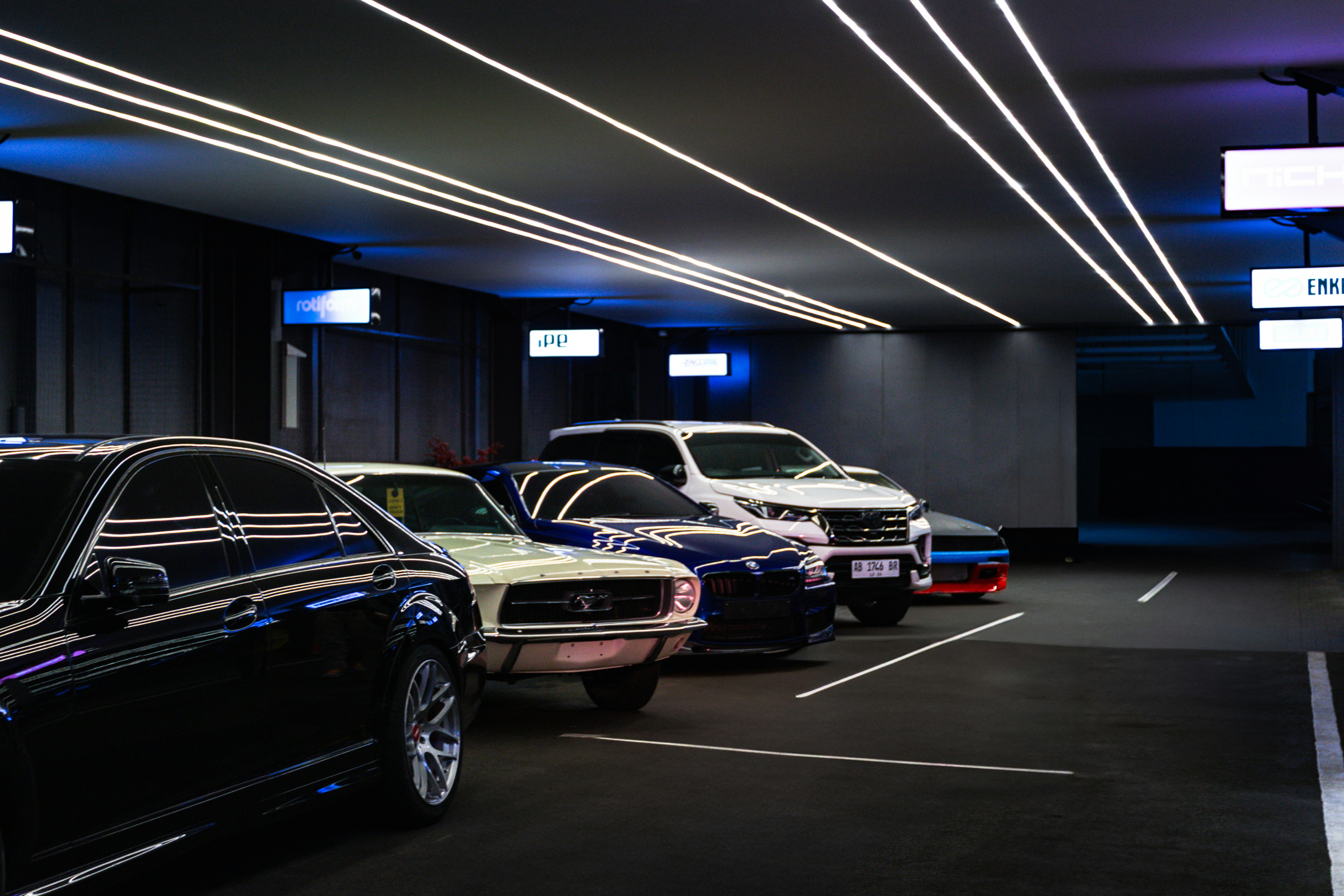 Cars are parked in a well-lit, modern garage. photo – Free Cars Image ...