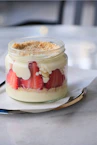 Strawberry dessert layered in a glass jar.