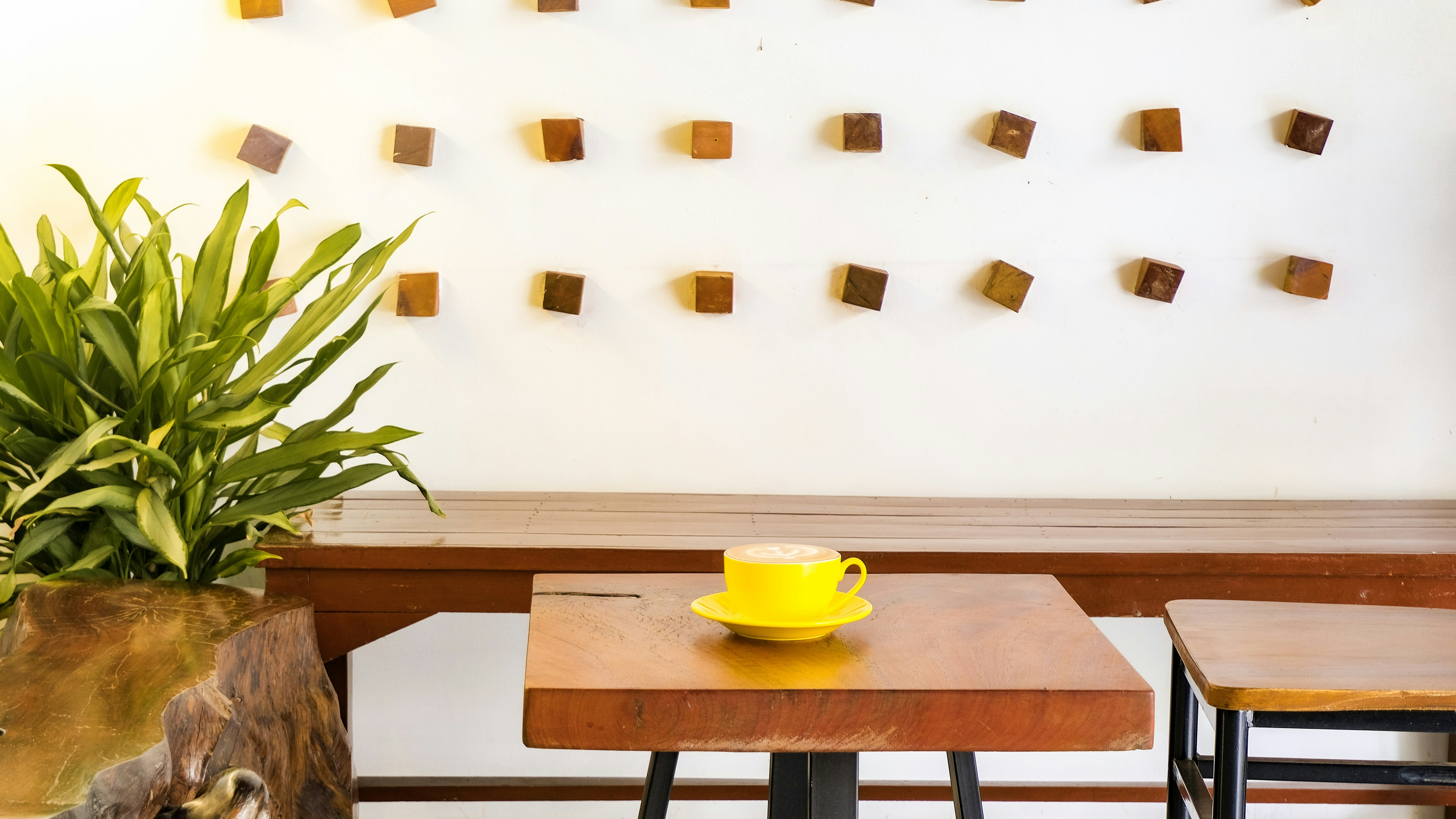 A yellow cup sits on a wooden table.