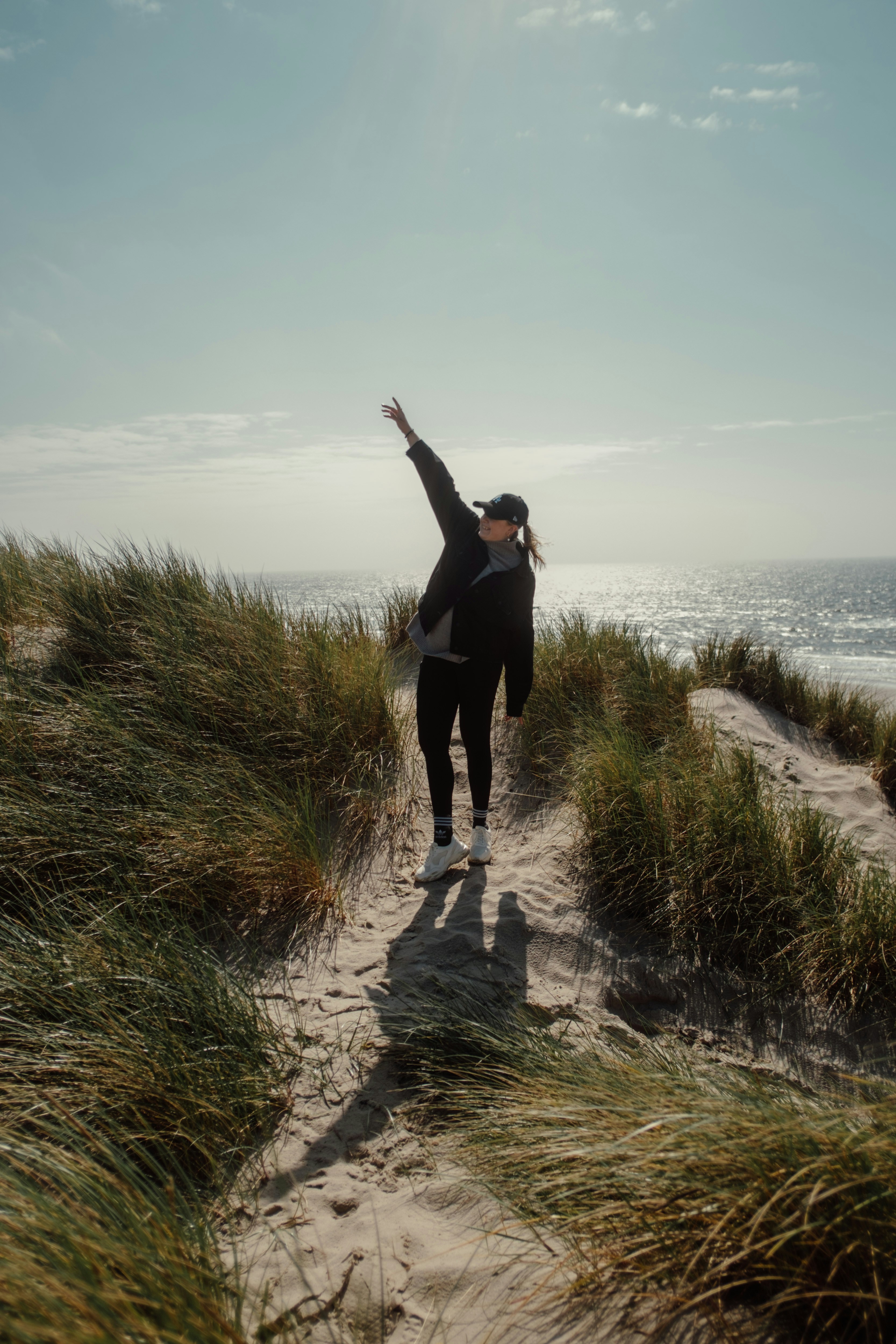 Woman celebrates freedom on a sandy beach.