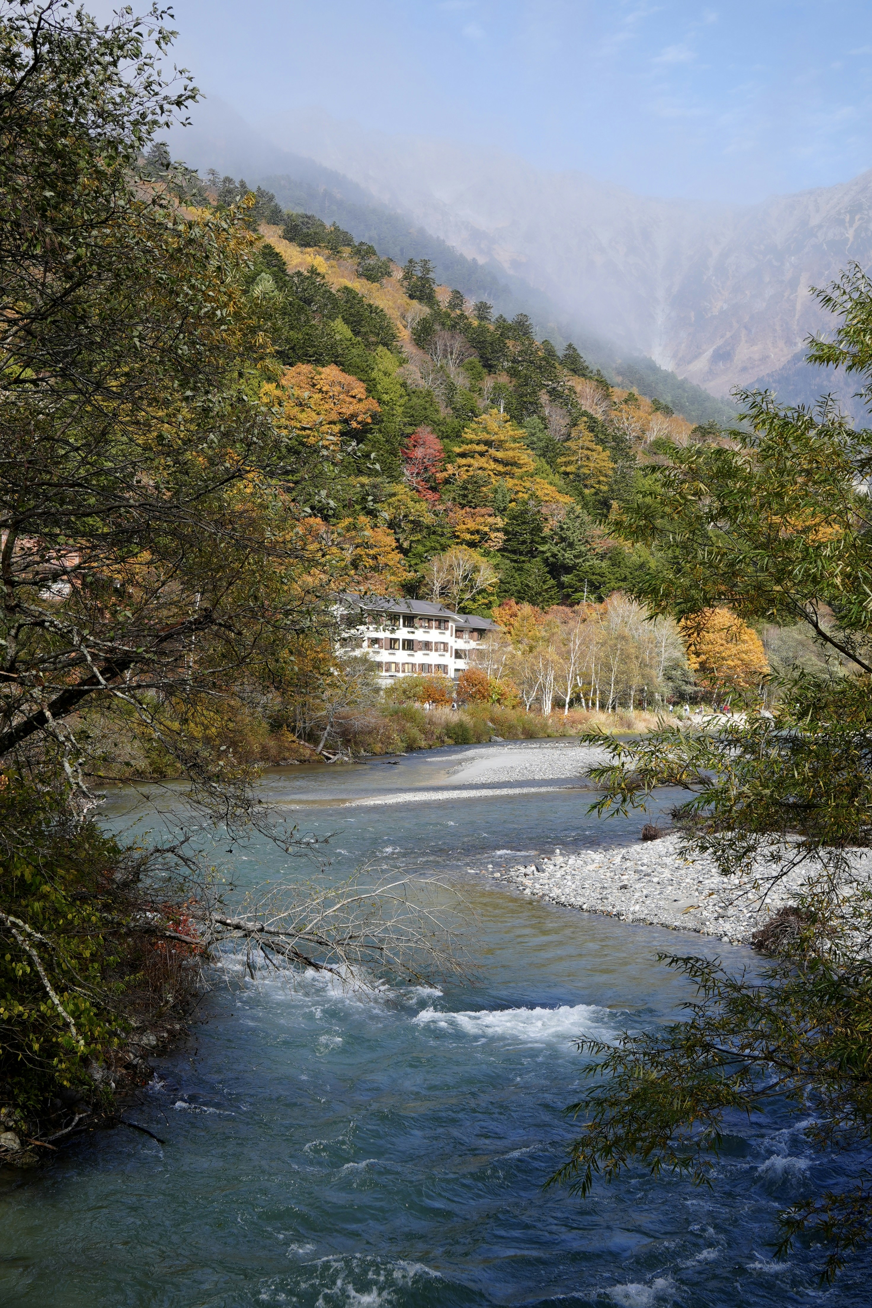 Autumn colors frame a flowing river and mountains.