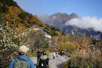 People hike toward a mountainous landscape.