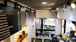 A coffee shop with a menu on the wall.