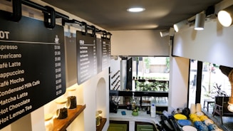 A coffee shop with a menu on the wall.