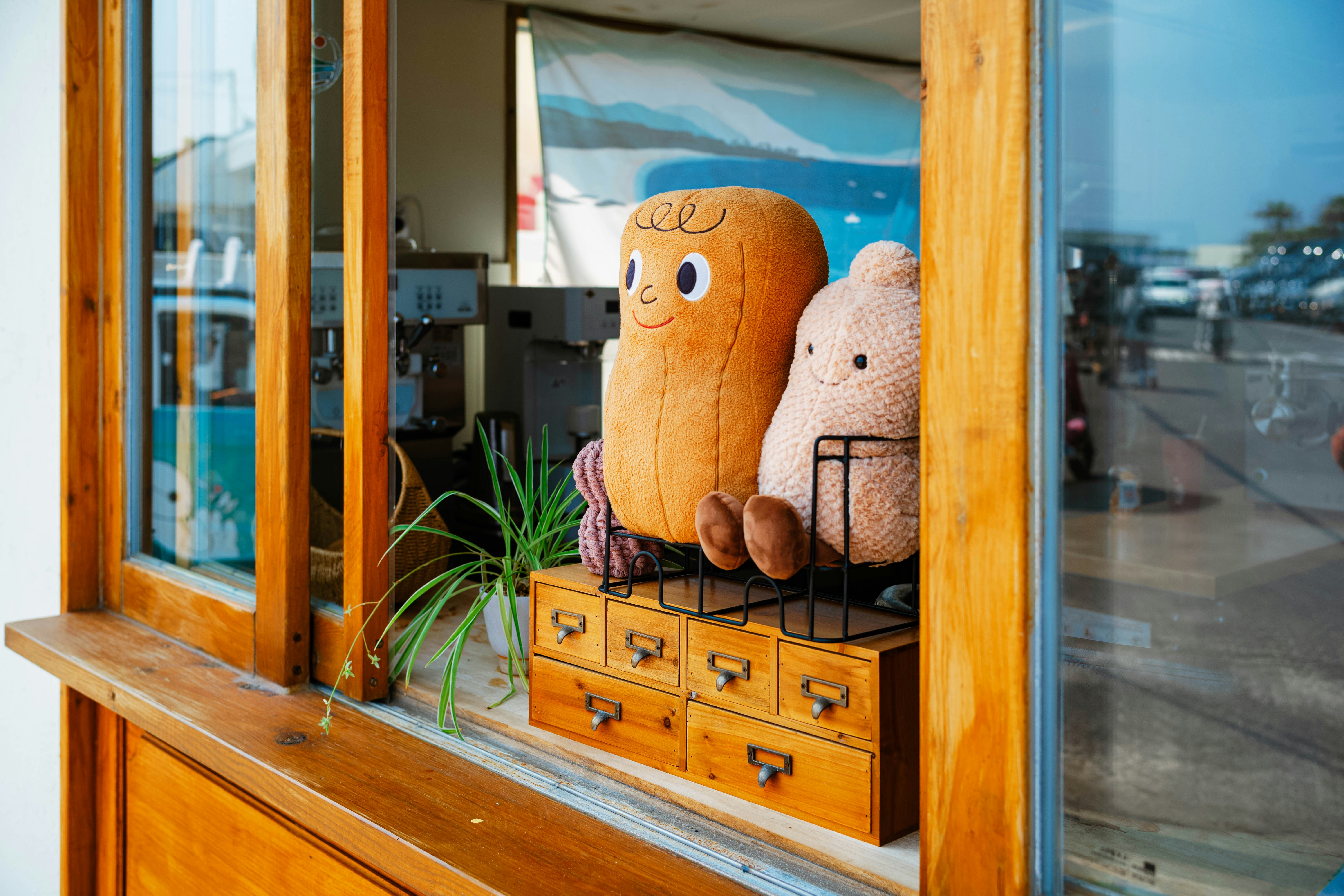 Two plush toys sit by a window.