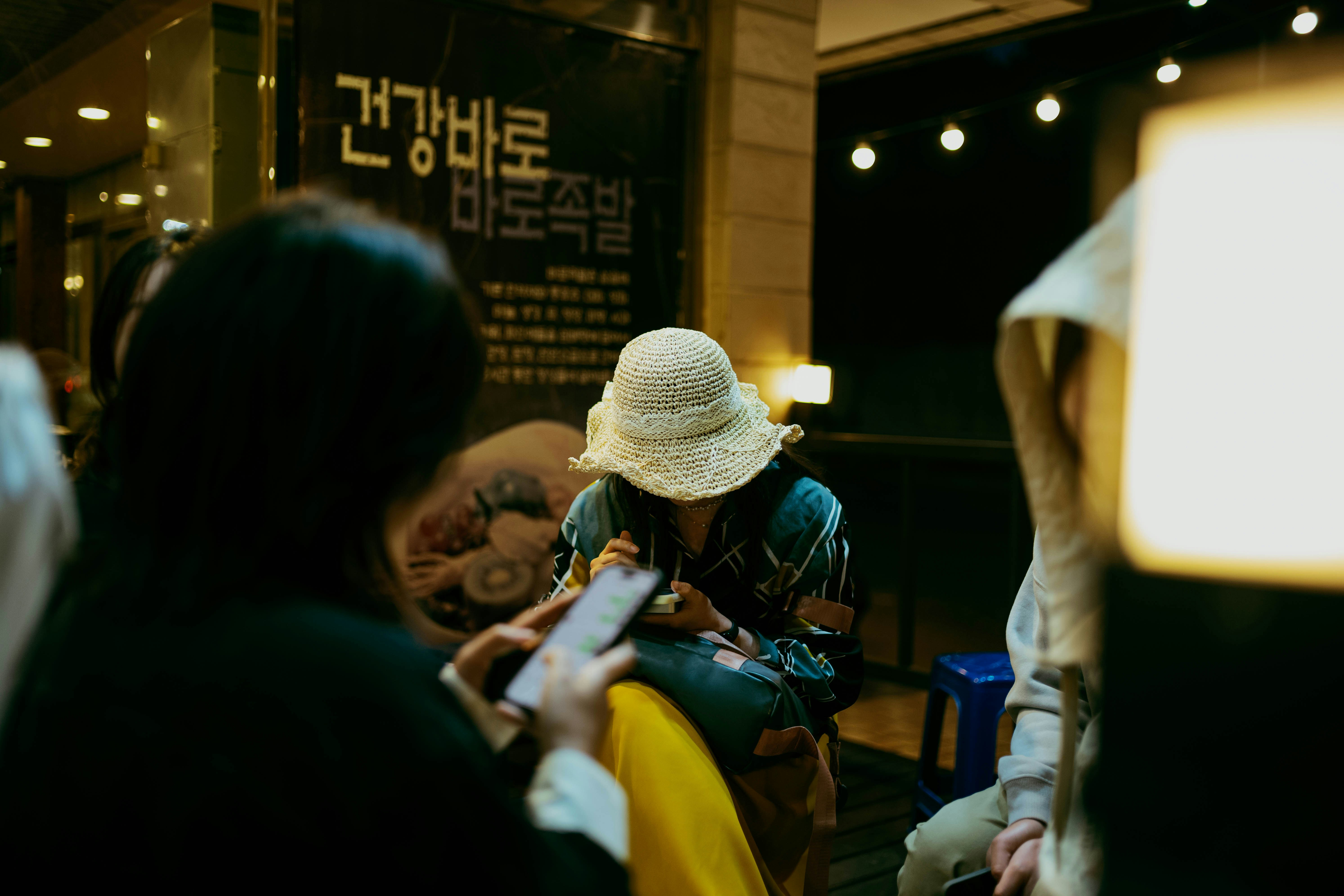 People are seen near a lit-up sign.