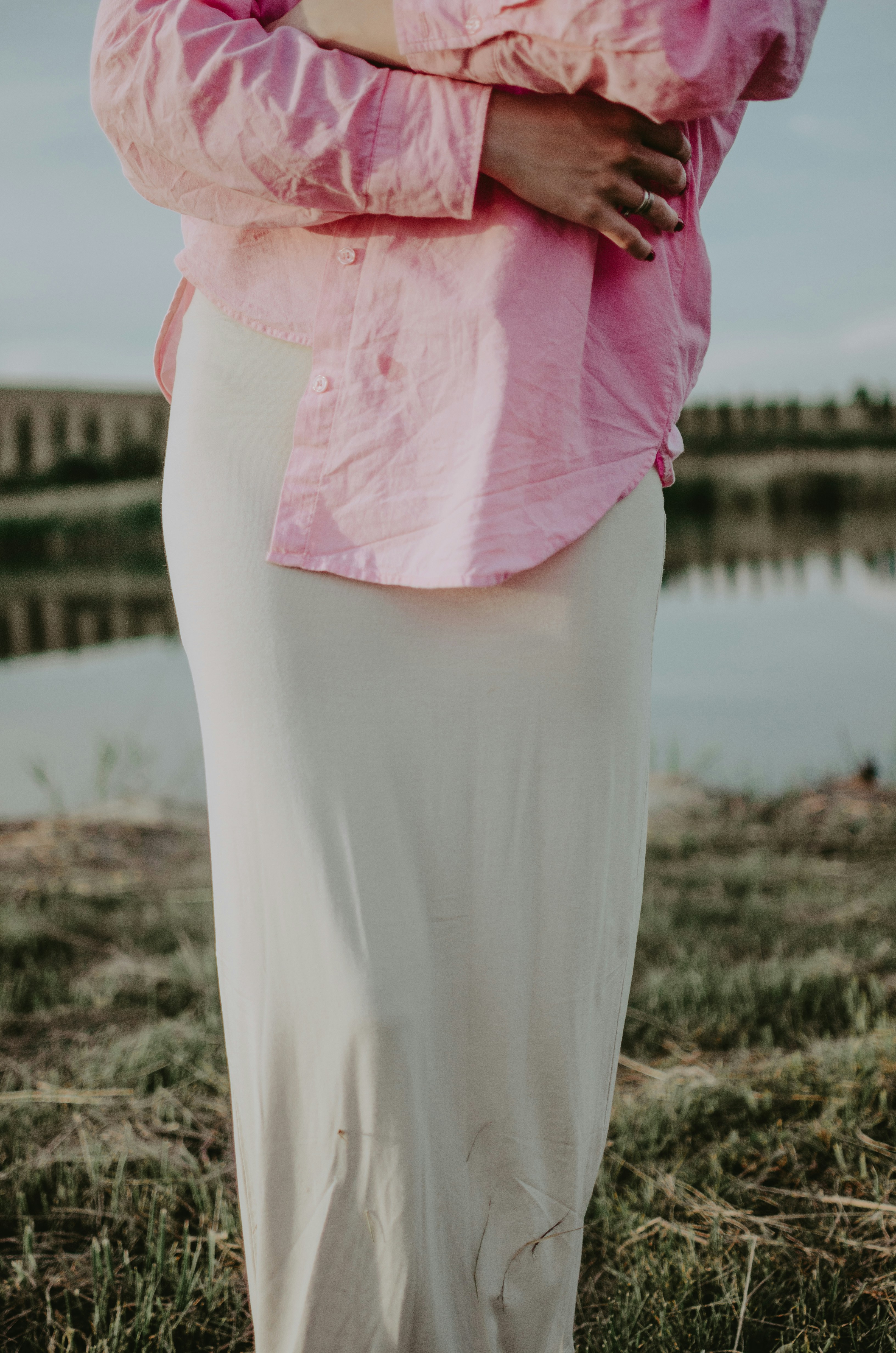 A person wears pink shirt and beige skirt.