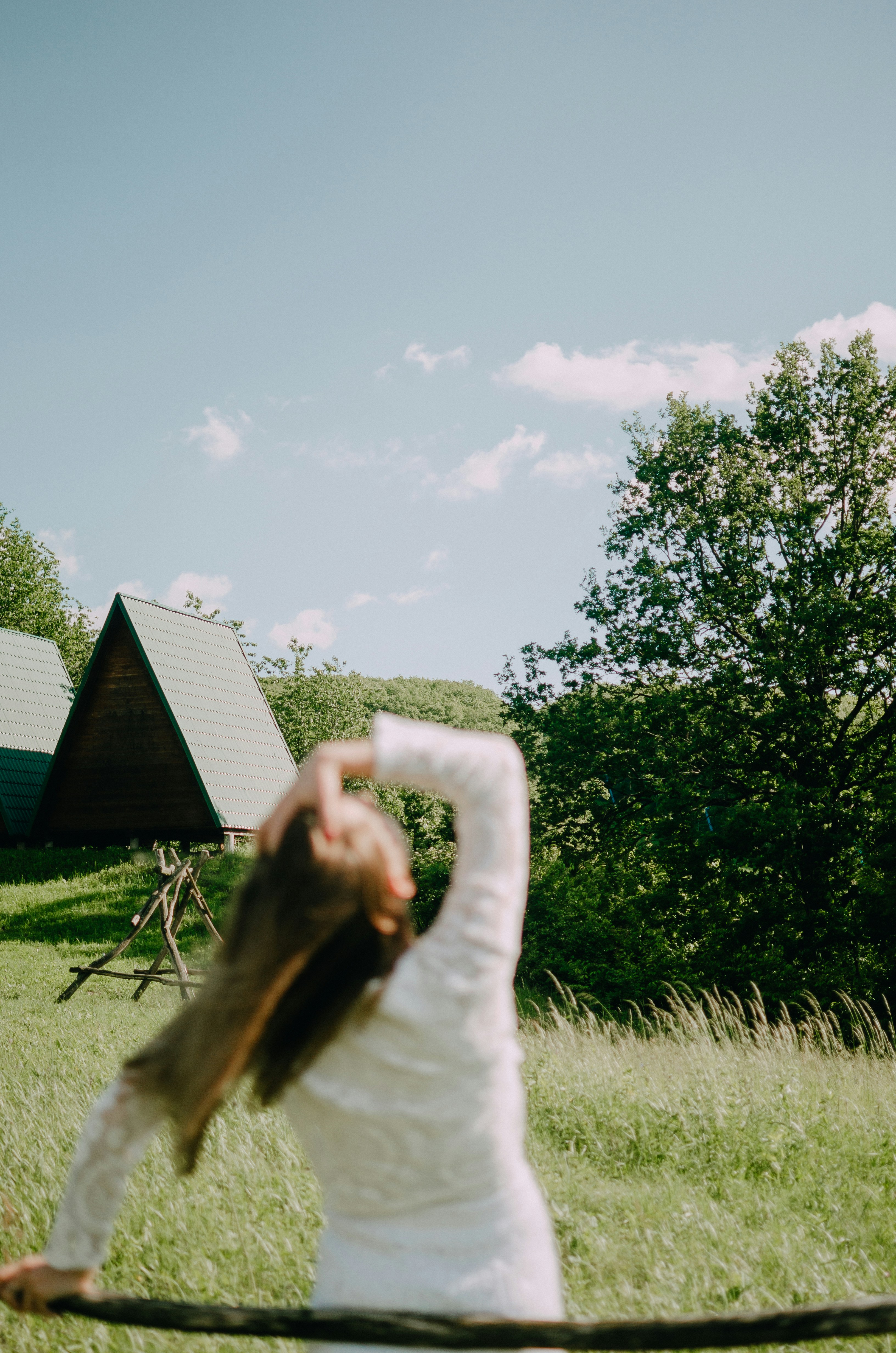 Woman stretches her arm towards the sunny sky.