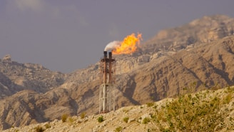 A flare burns over a rocky, desert landscape.