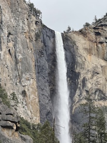 A tall waterfall cascades down a rocky cliffside.