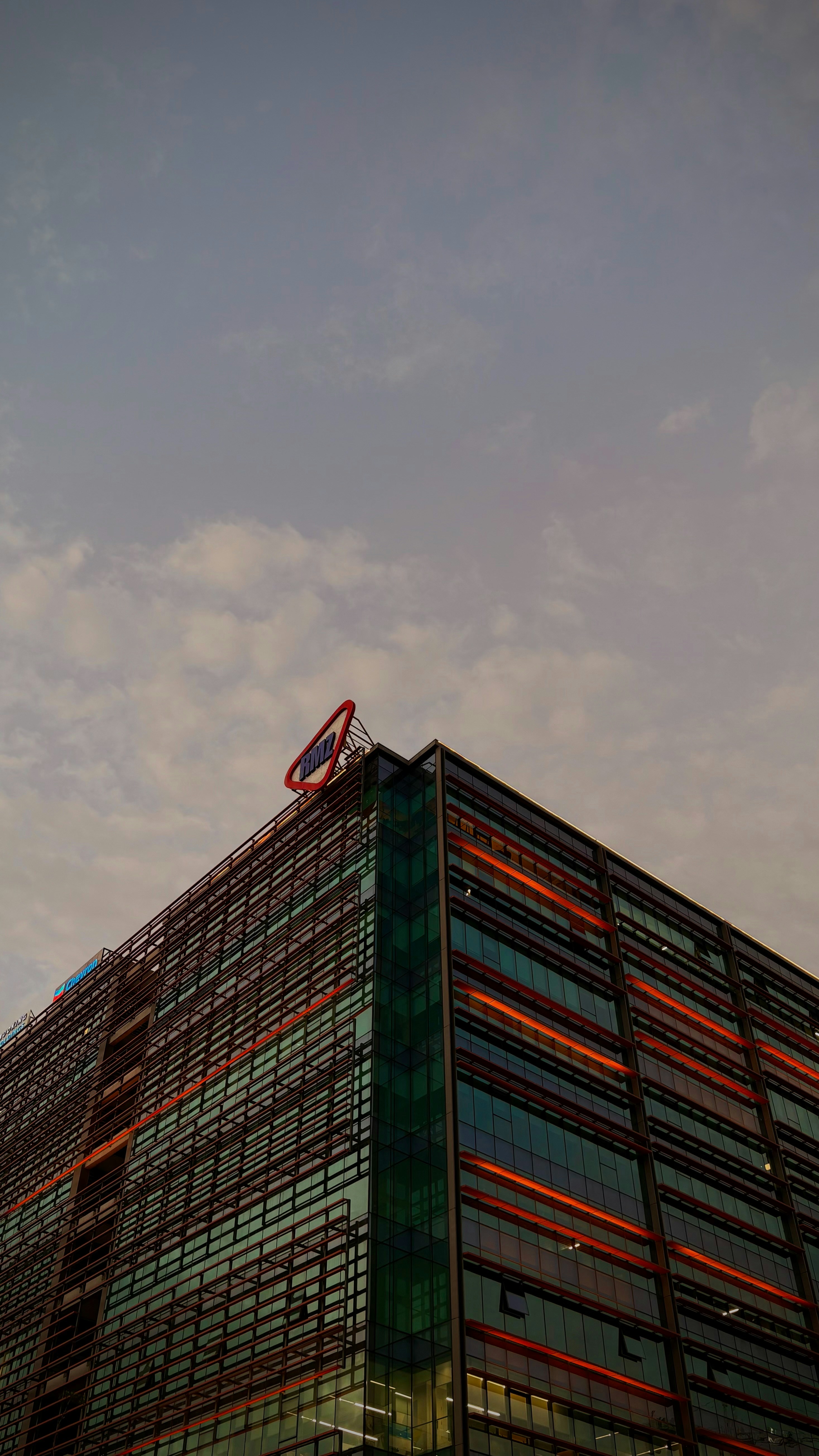 Modern building with a sign against cloudy sky.