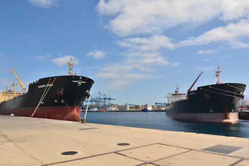 Two cargo ships docked at a harbor.