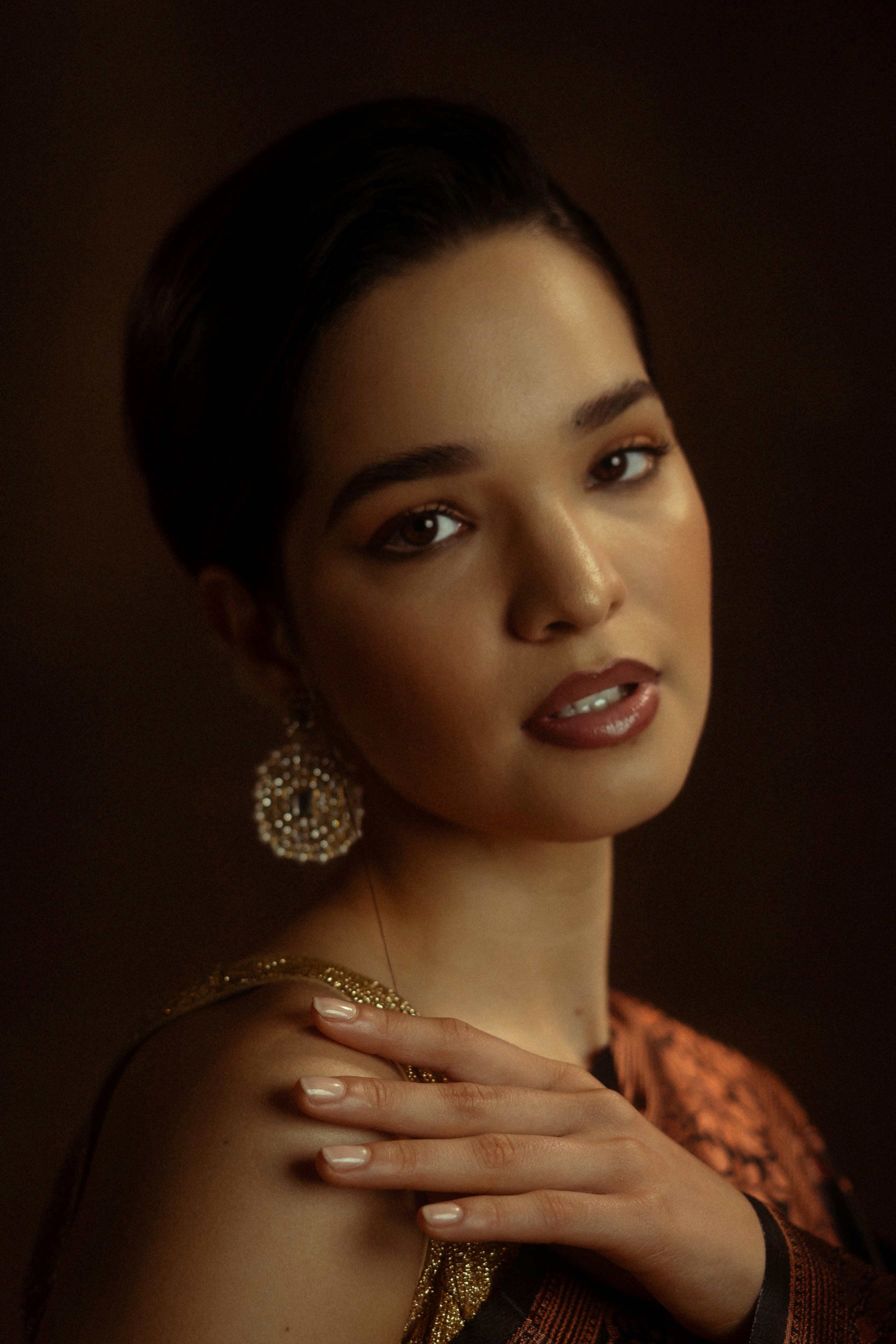 Schöne Frau, die mit dramatischem Make-up und Schmuck posiert.