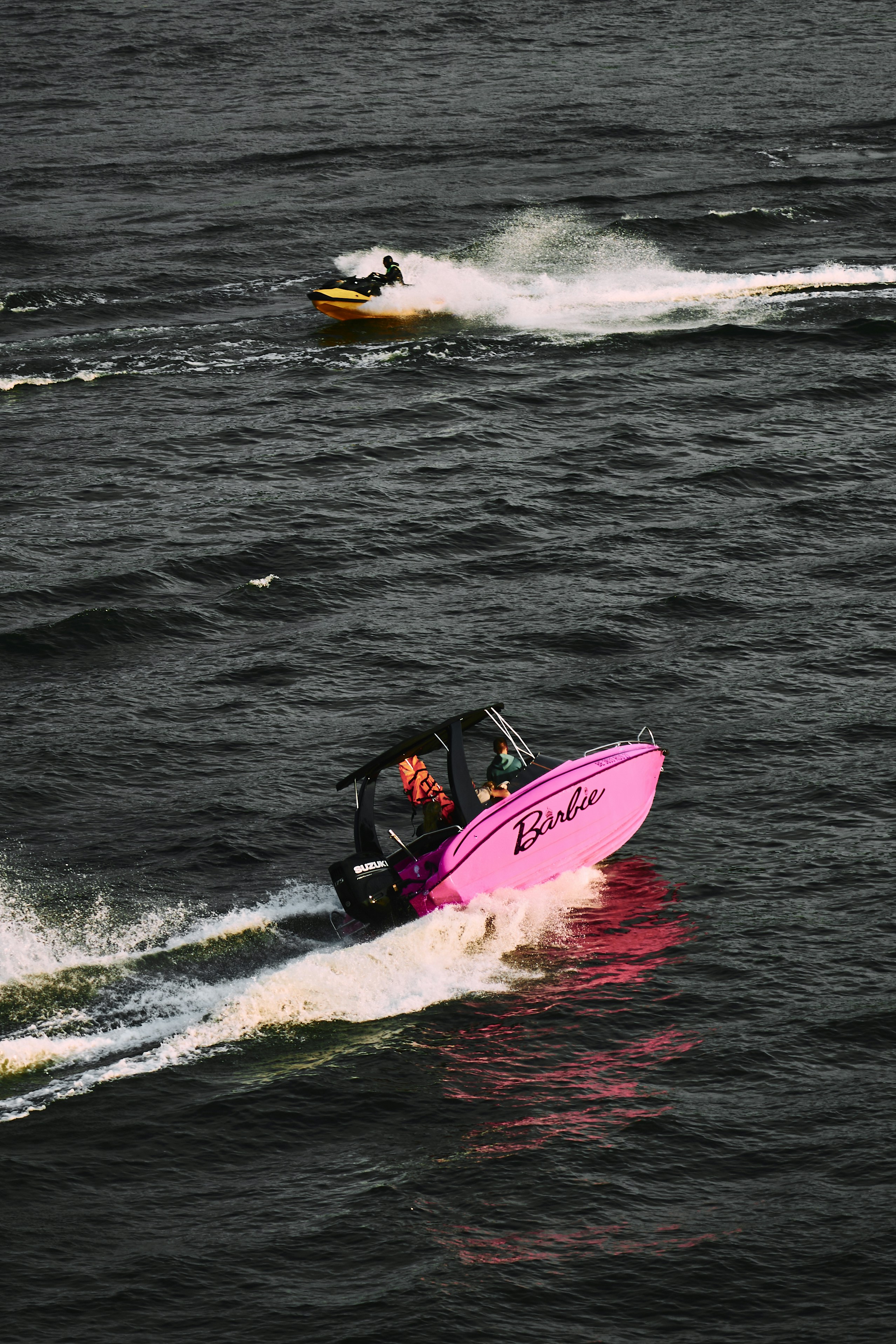 Two boats race across choppy water.