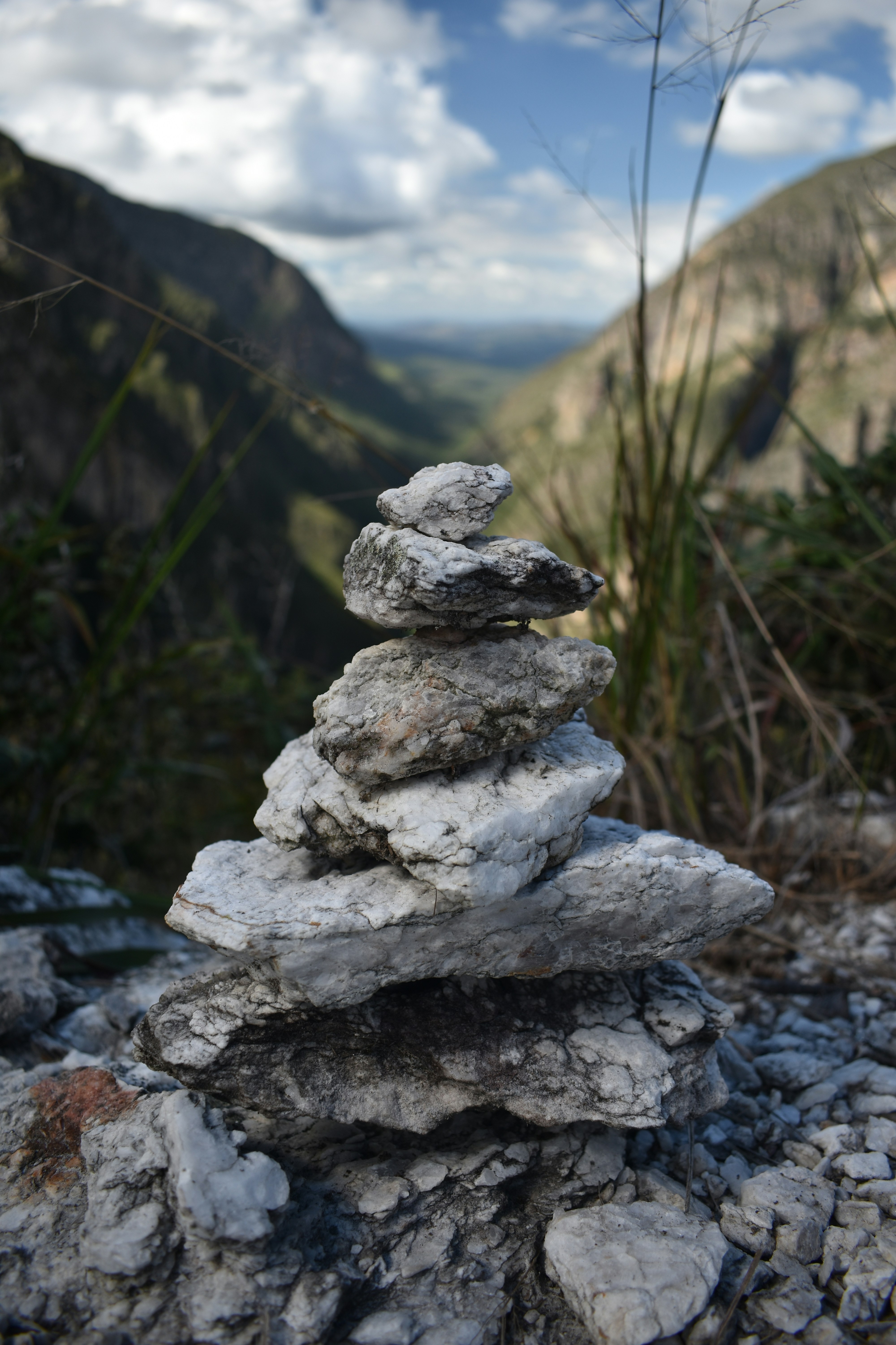 Stone cairn sits peacefully in a mountainous landscape.