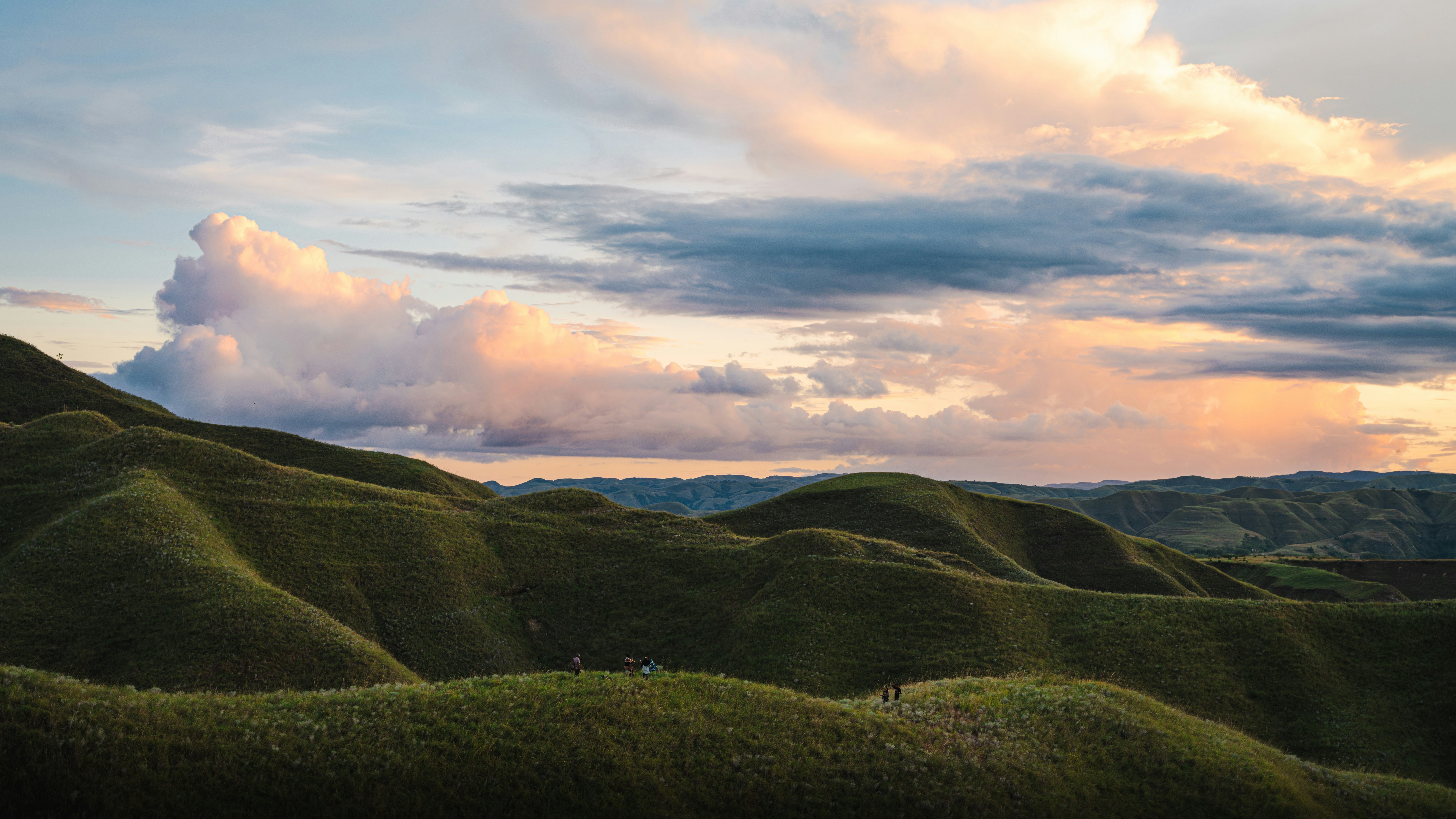 Hills are under a dramatic, colorful sky.