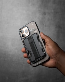 A phone with a wallet case is held.