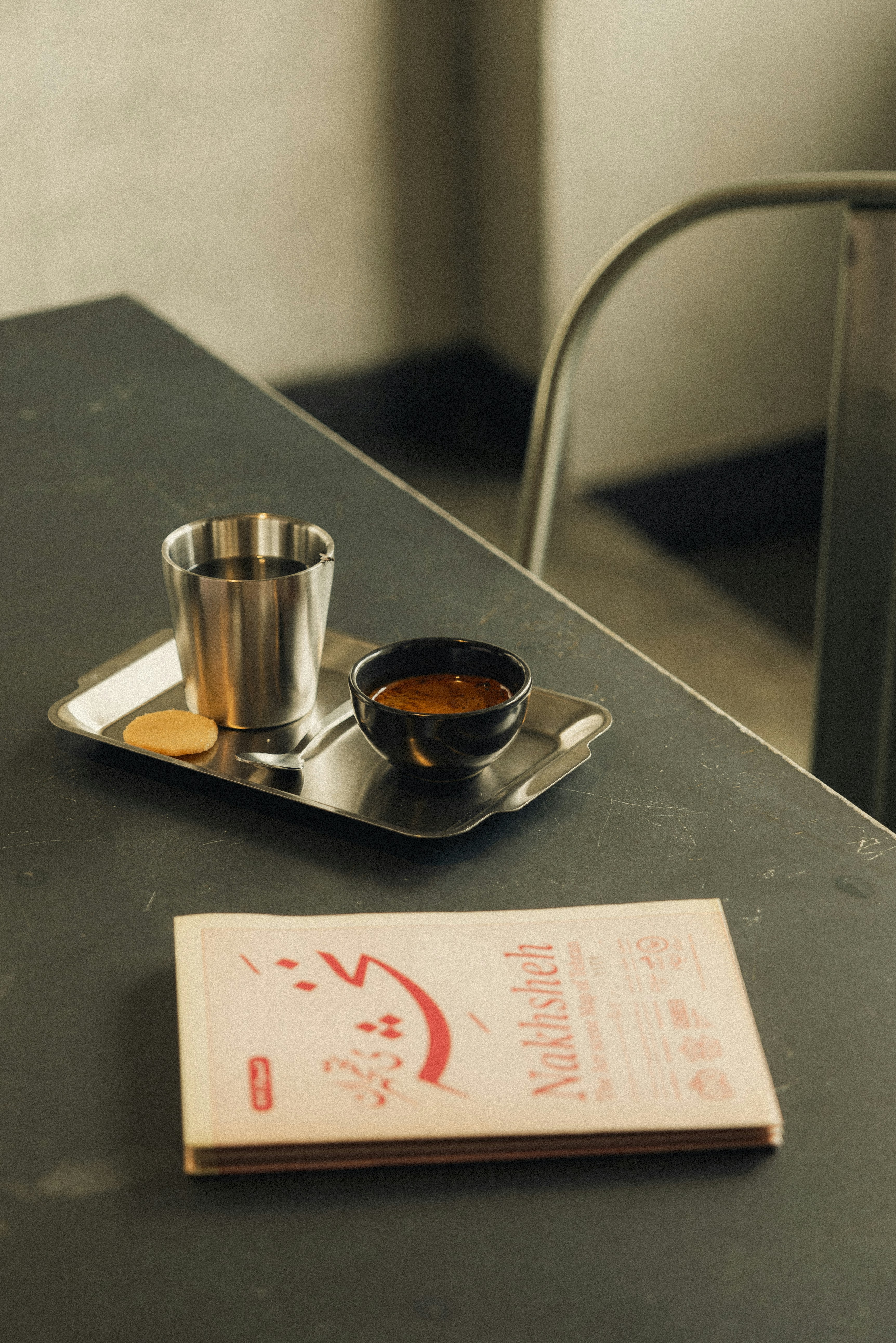 Coffee and a treat sit on a table.