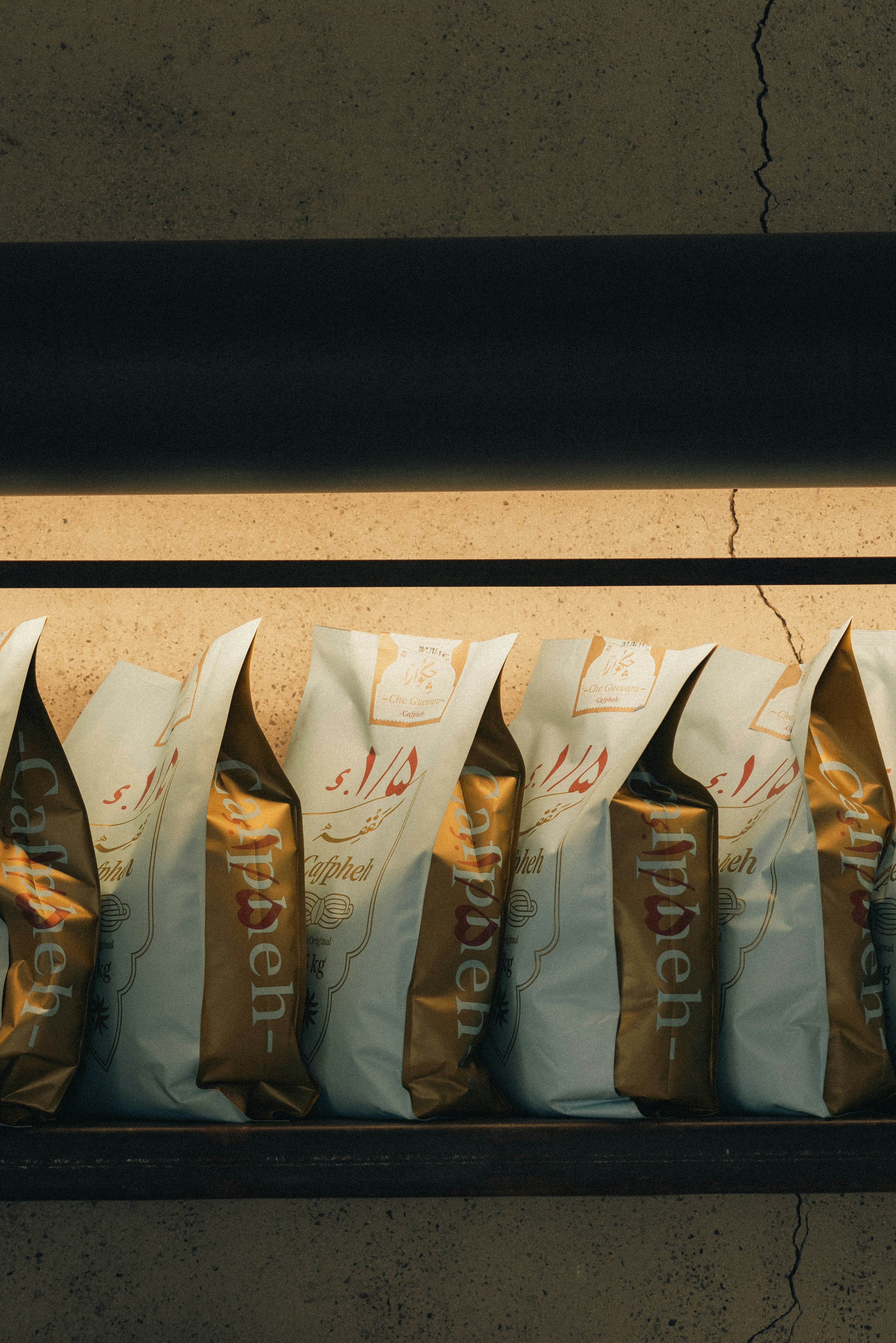 Coffee bags are lined up on a shelf.