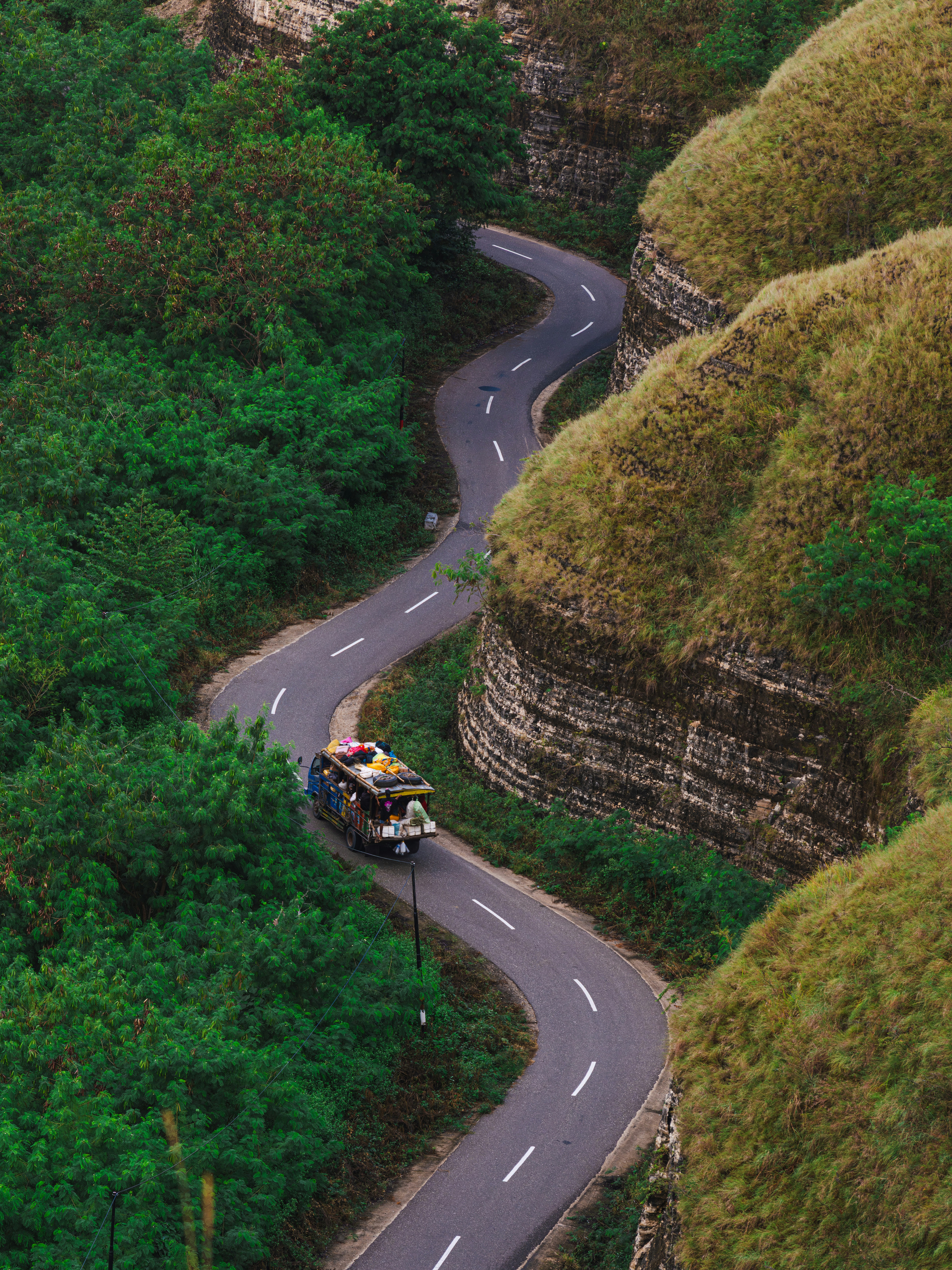 A winding road leads through lush green terrain.