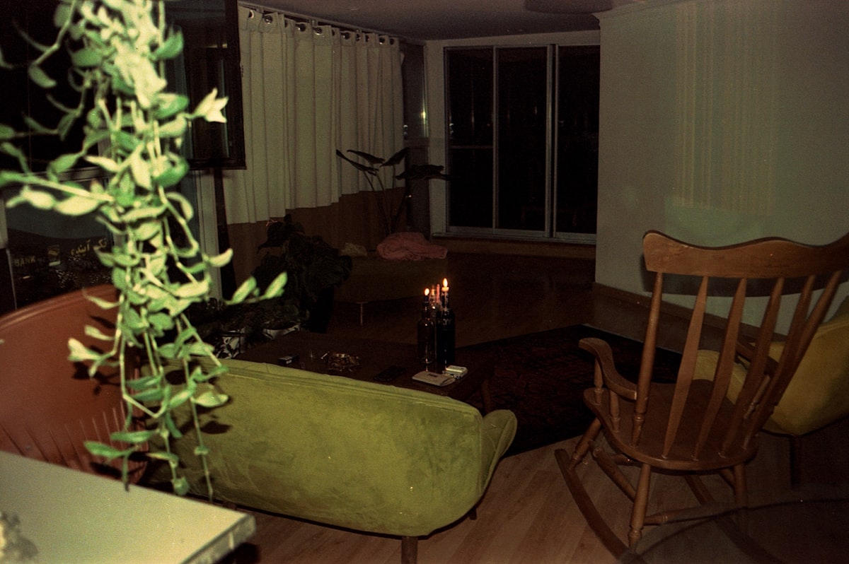 Apartment living room at night lit only by candles on coffee table