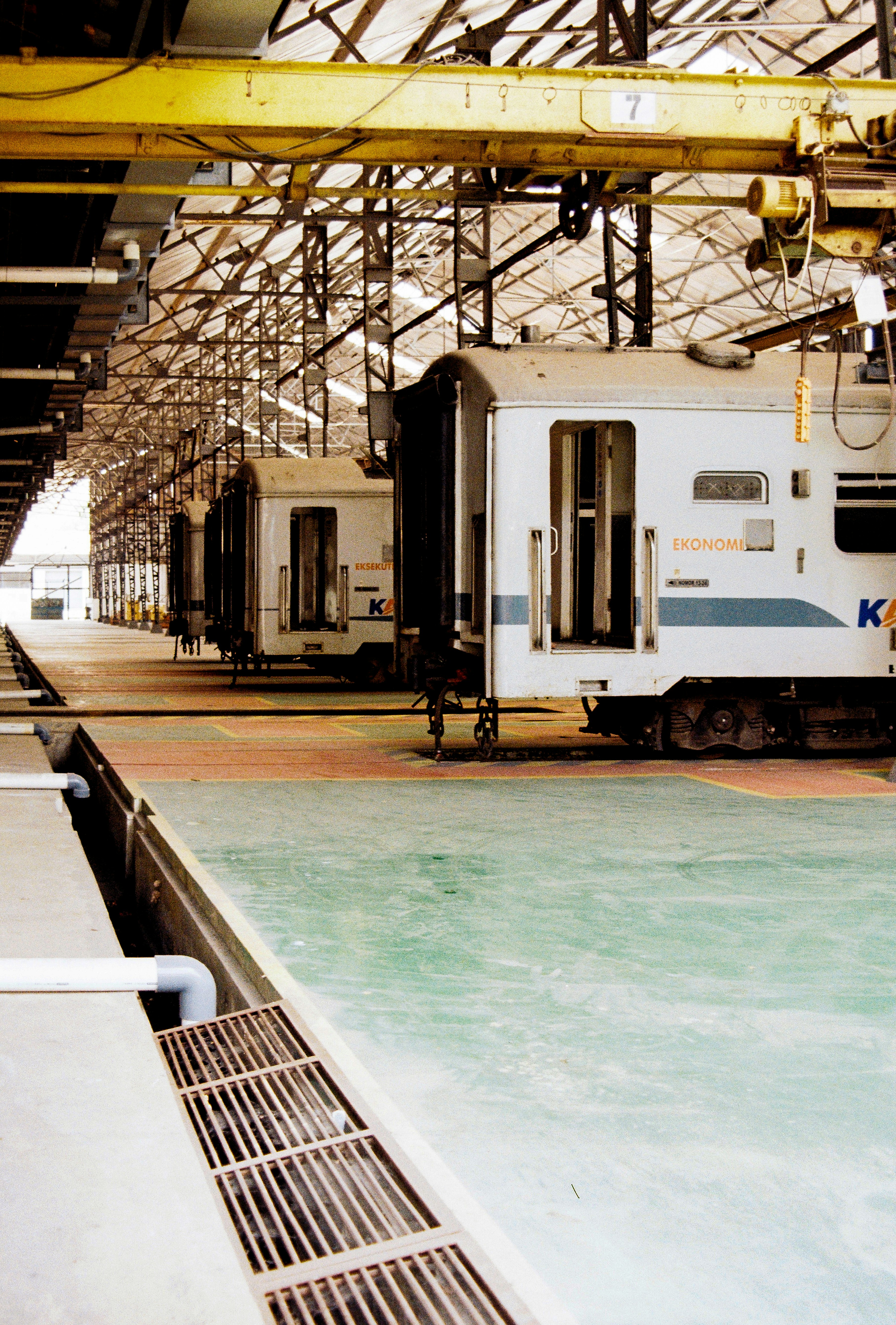 Train cars parked inside a large industrial workshop