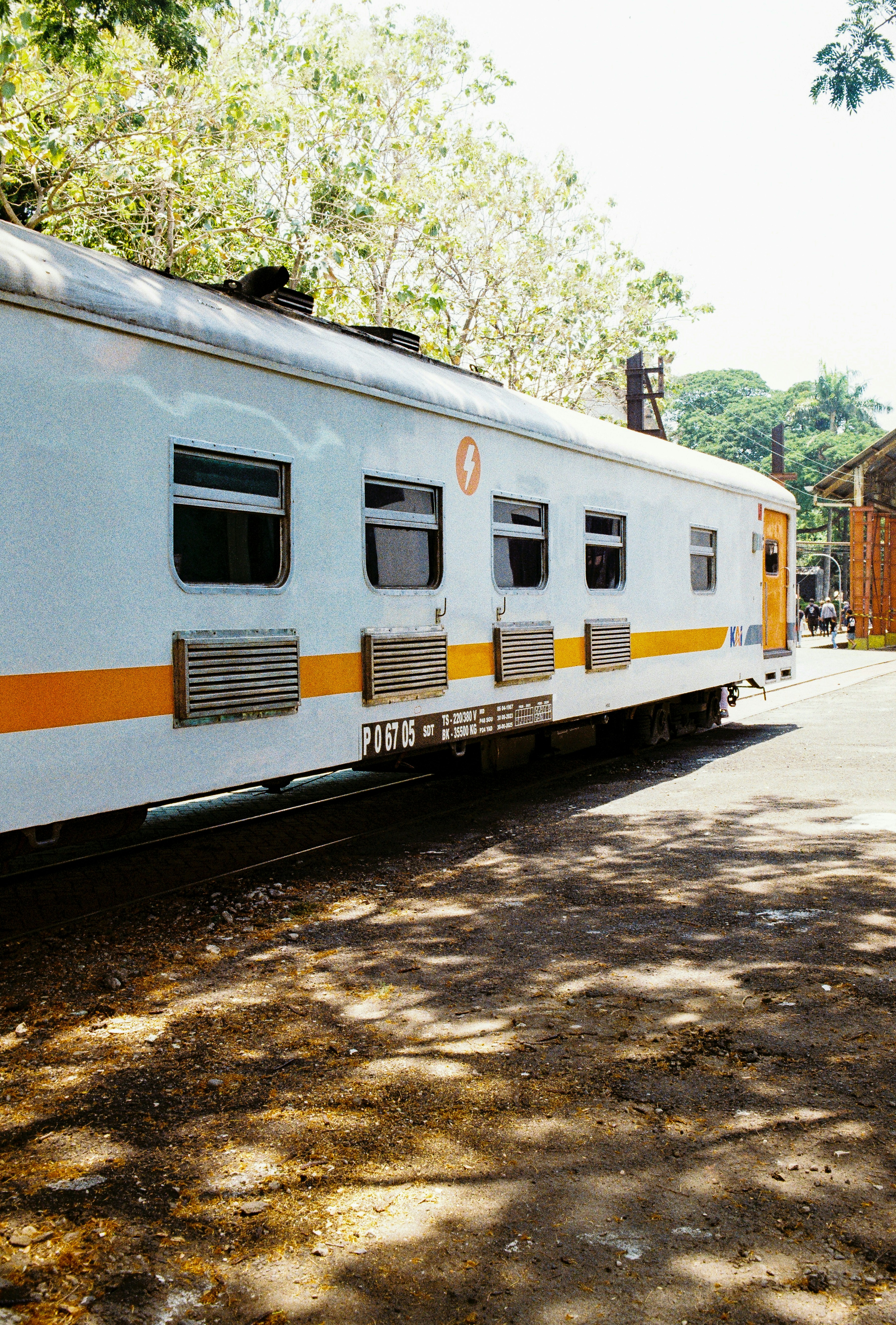 A white train car parked beside tracks.