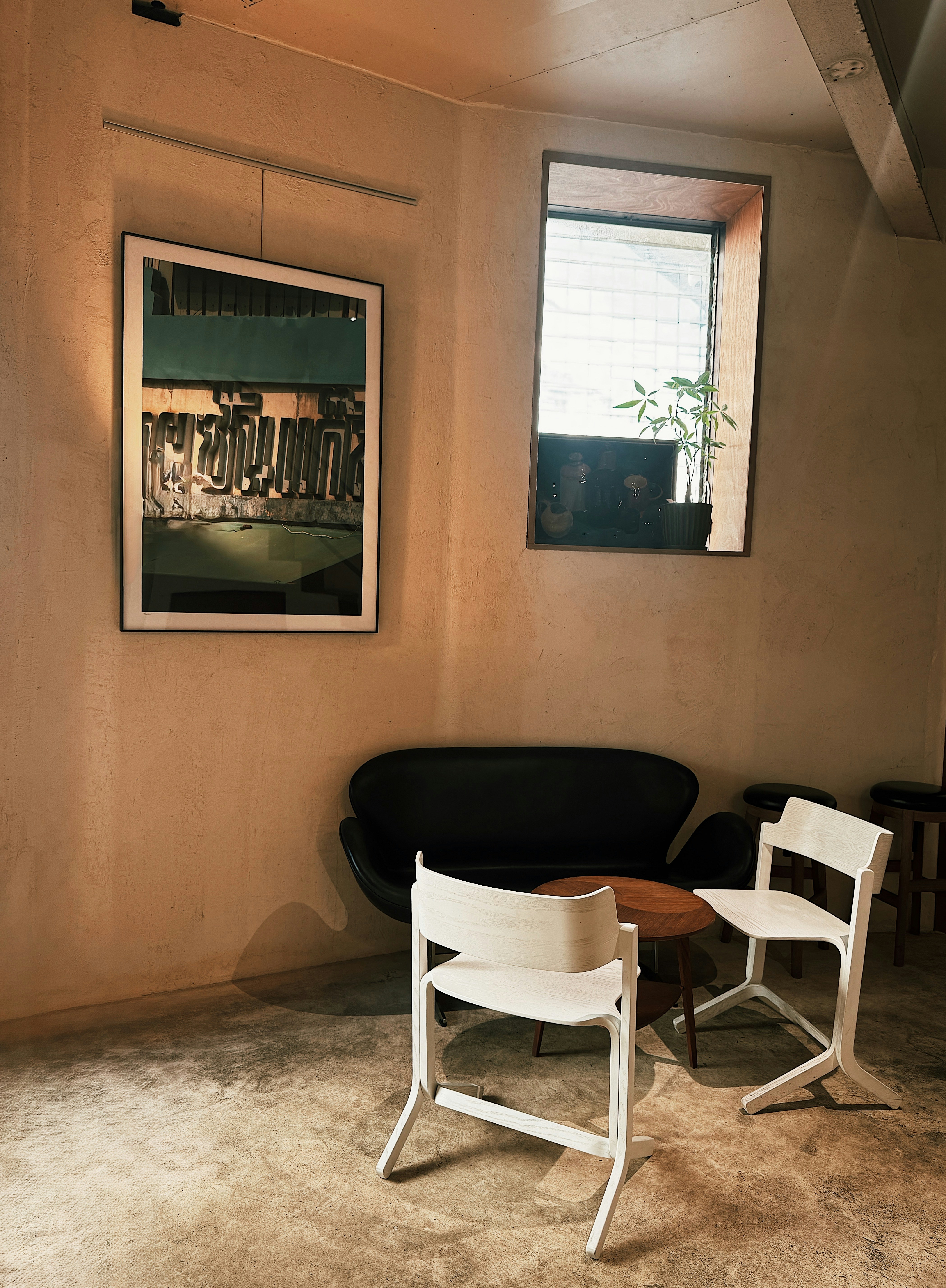 Cozy corner in a cafe with chairs and artwork.