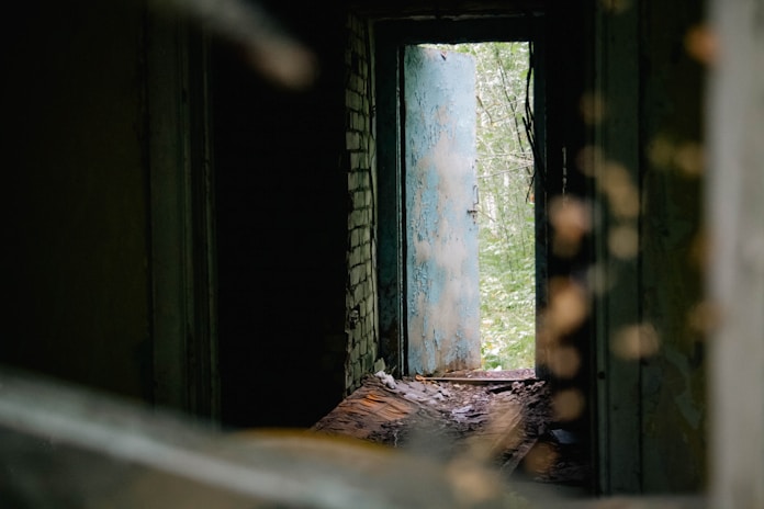 A doorway reveals a bright green outside.