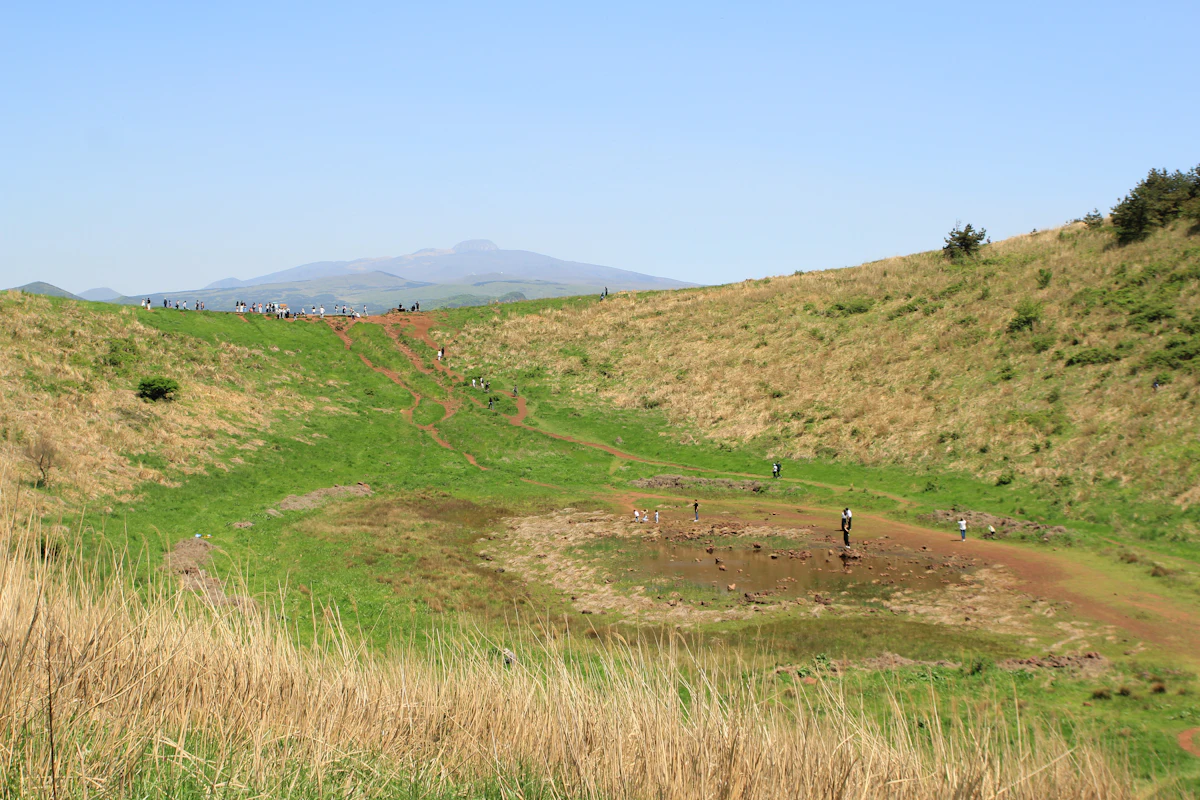 The grassy crater of Geumoreum, a small volcanic cone on Jeju, with Hallasan on the horizon
