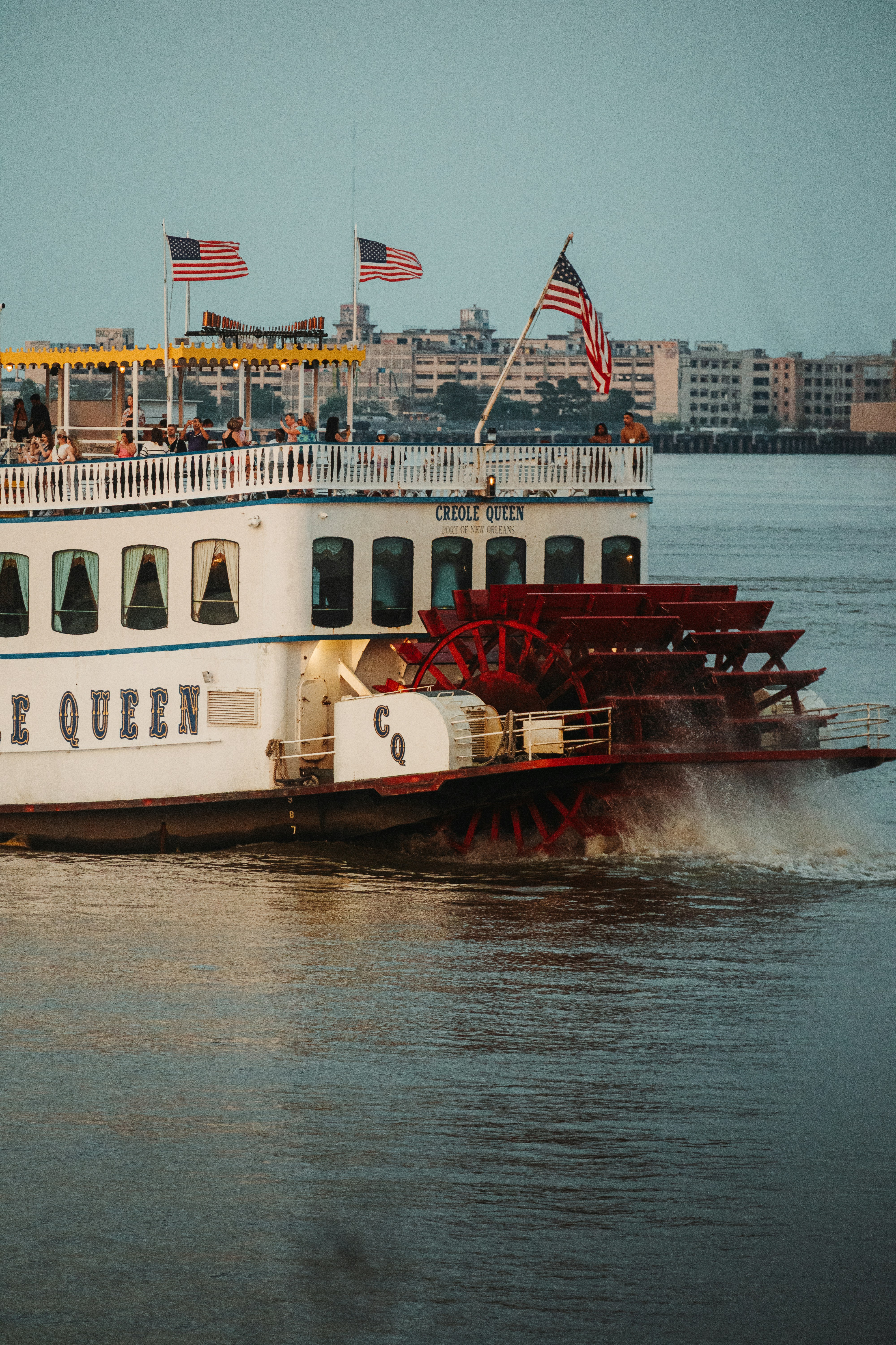 The paddle boat queen cruises on the water.