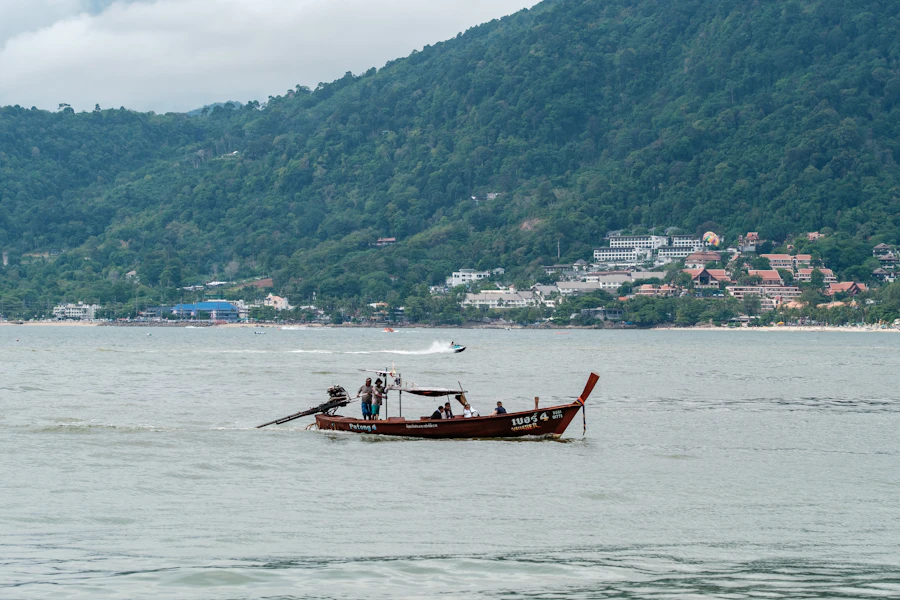 A longtail boat on Patong Bay below the green hills of Patong