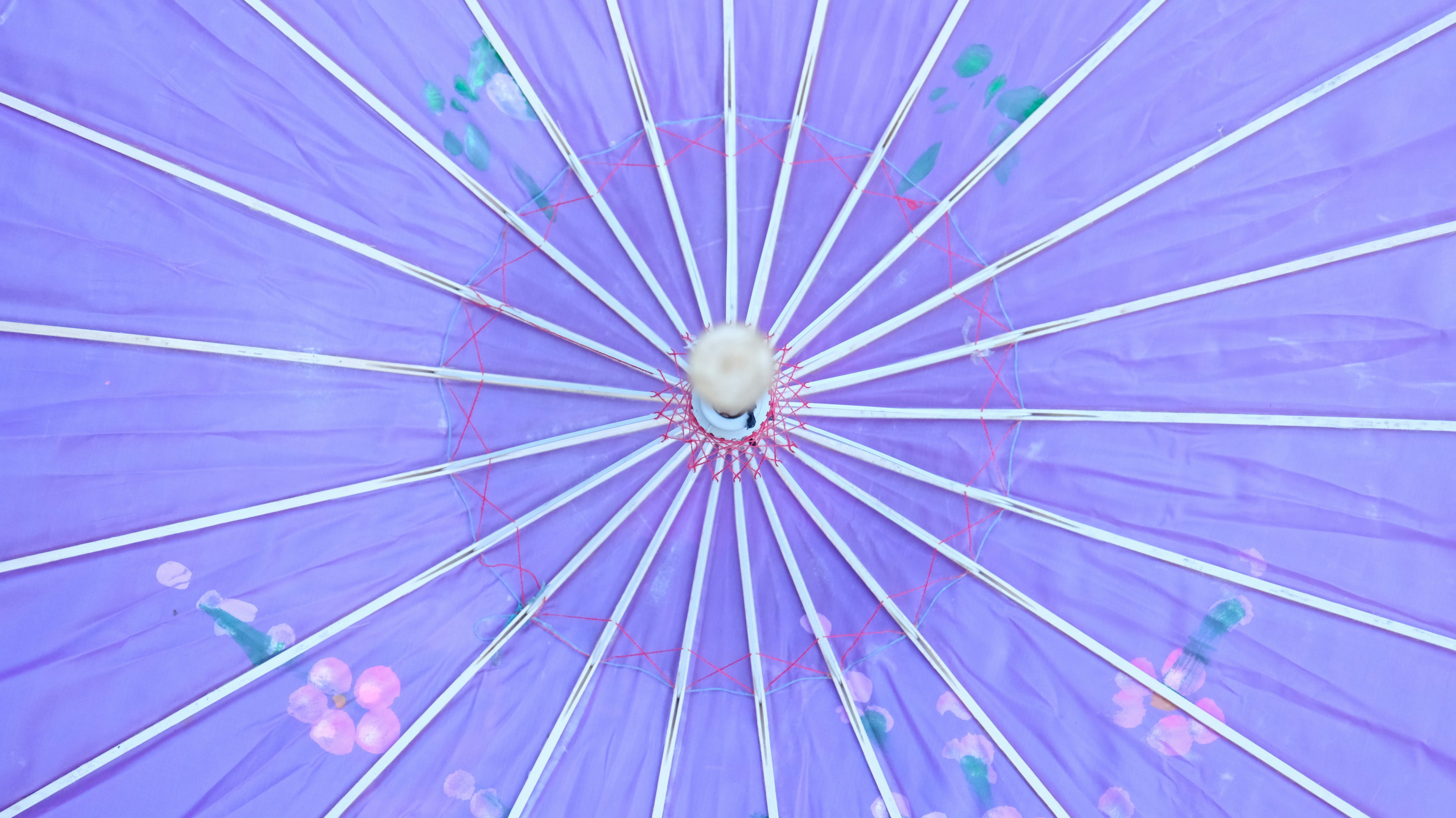 The inside view of a purple paper parasol.