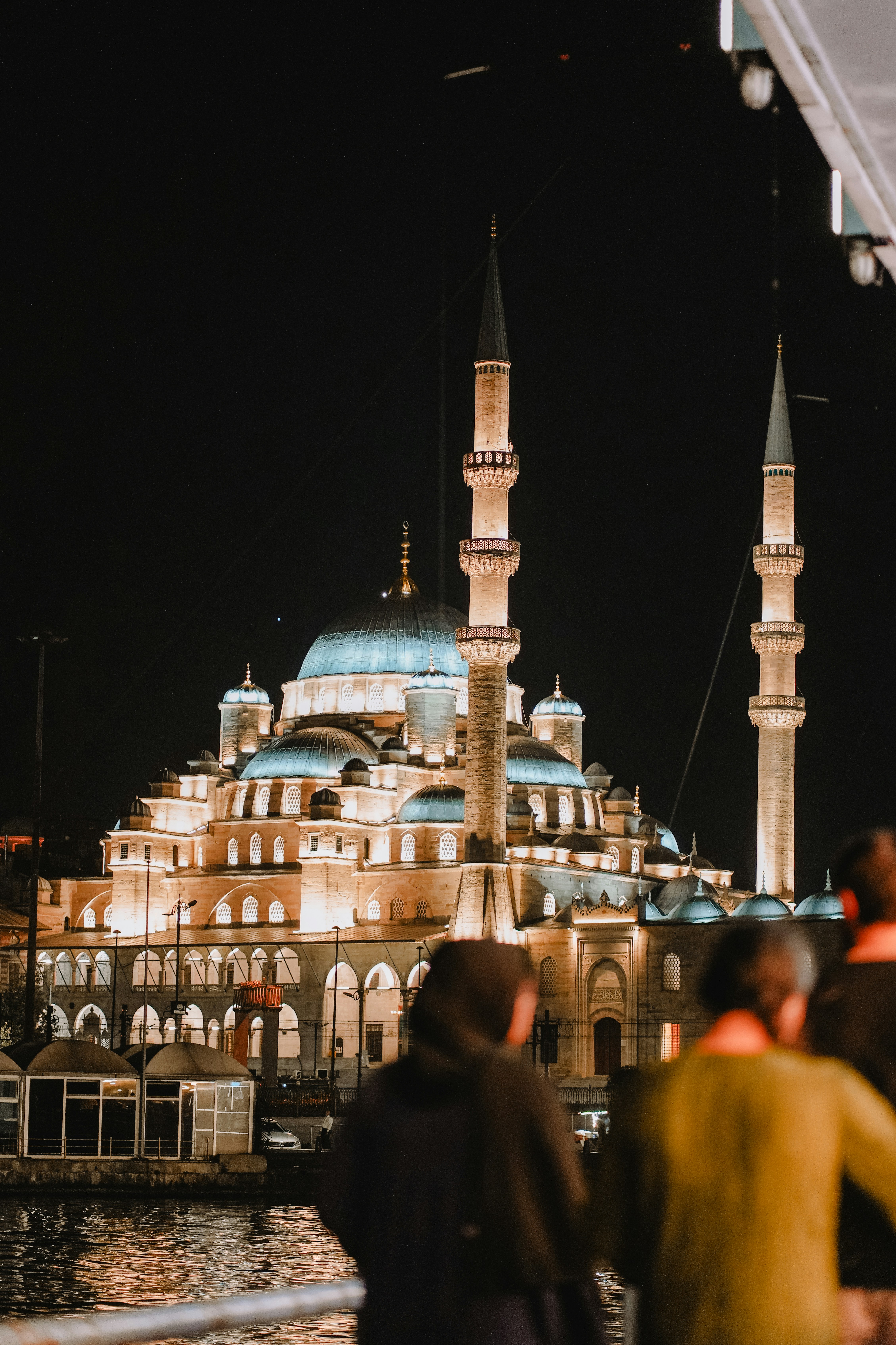 Night view of a mosque with glowing lights.