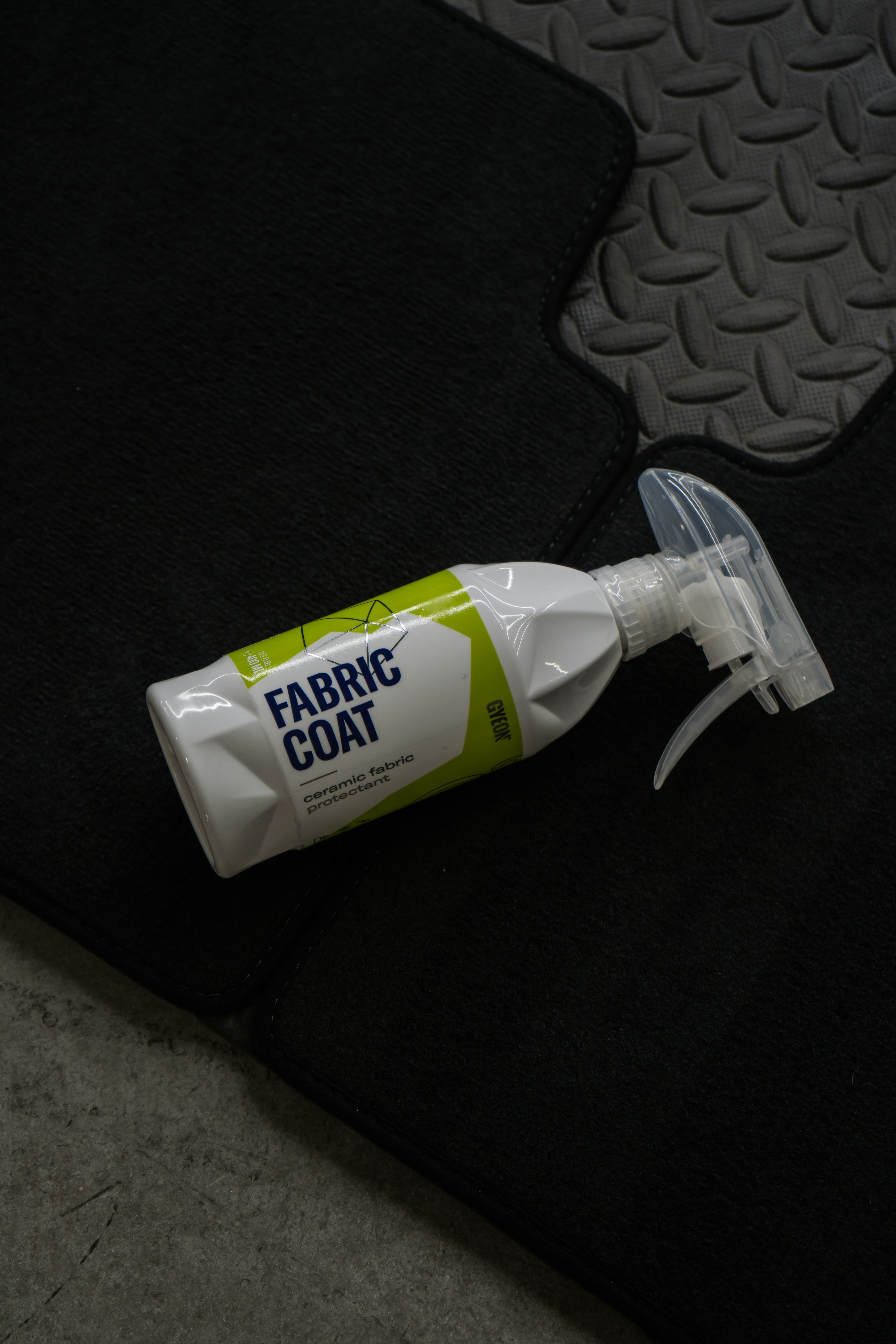 Fabric coat spray sits on a car mat.