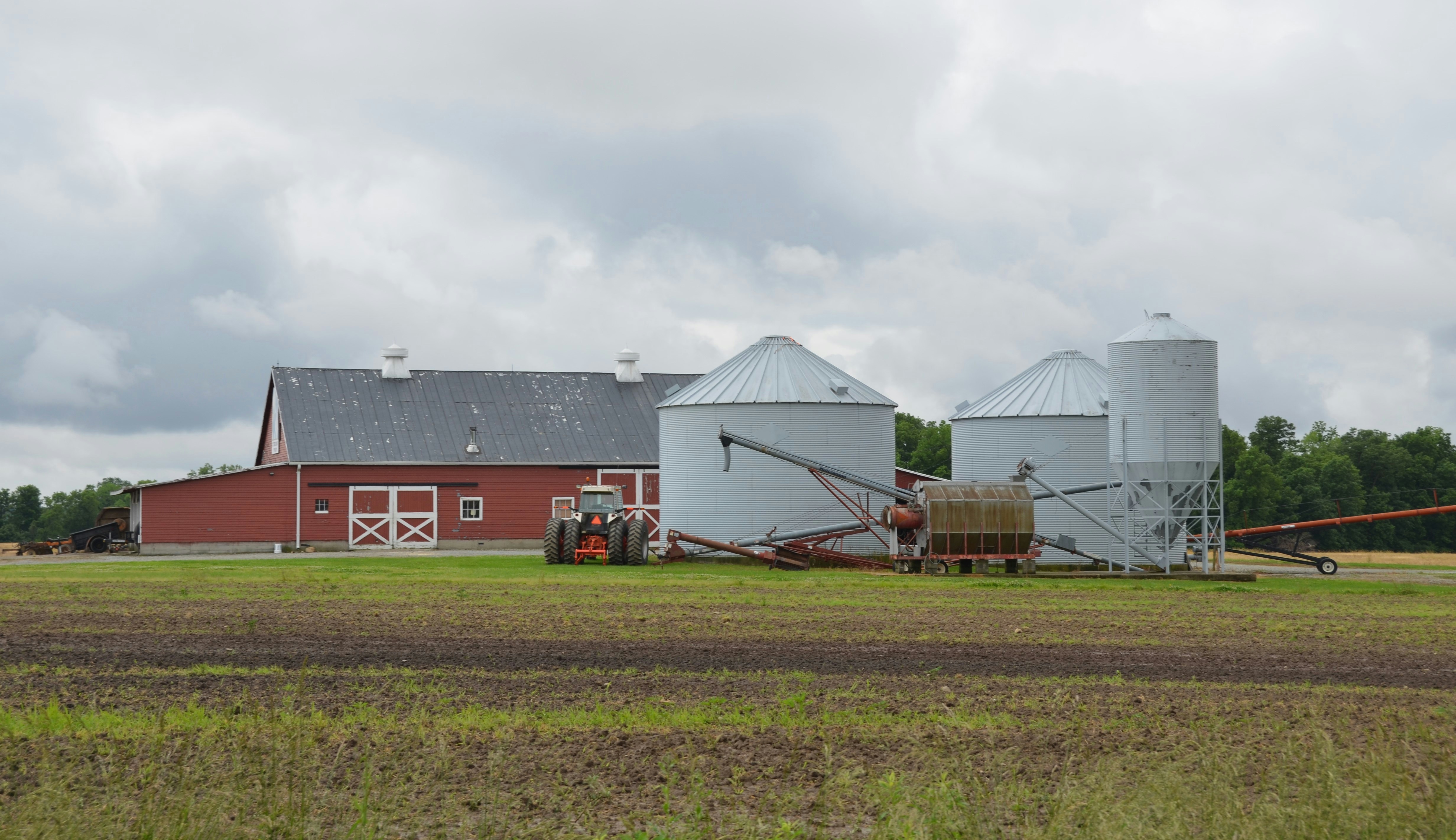 Una granja, un granero y unos silos se encuentran bajo un cielo nublado.  foto – Imagen gratuita en Unsplash, image size:3000x1731