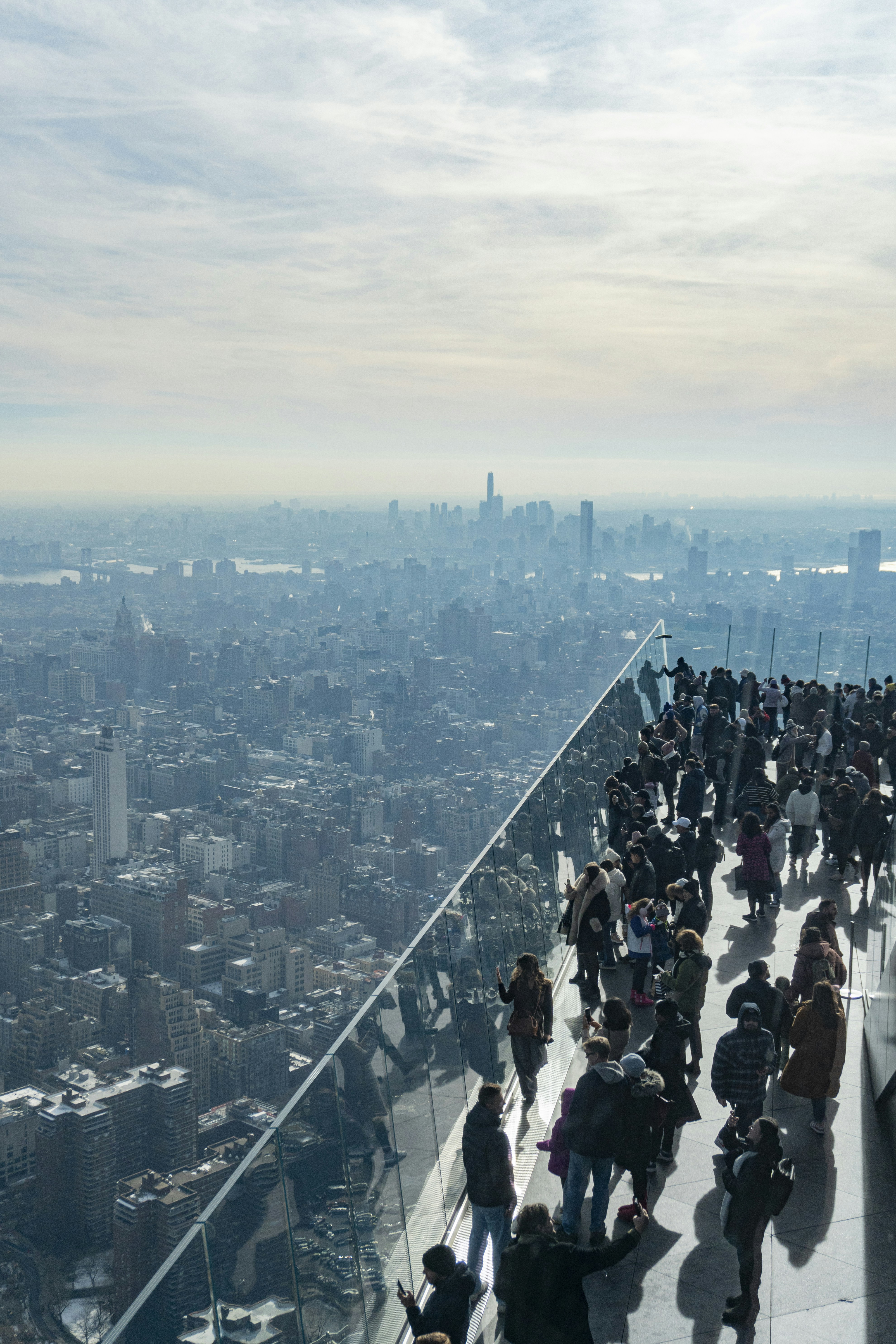 People enjoy city views from a high-rise platform.